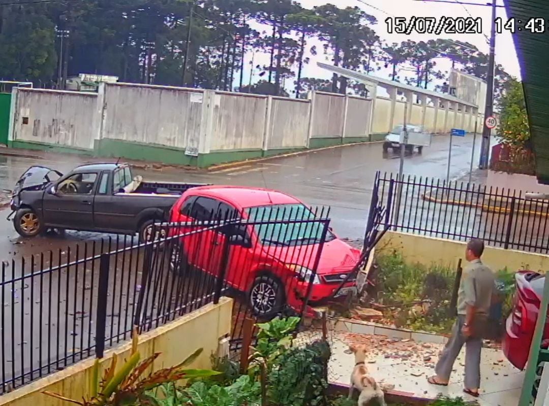 Momento de la colisión de dos turismos contra la casa de un hombre