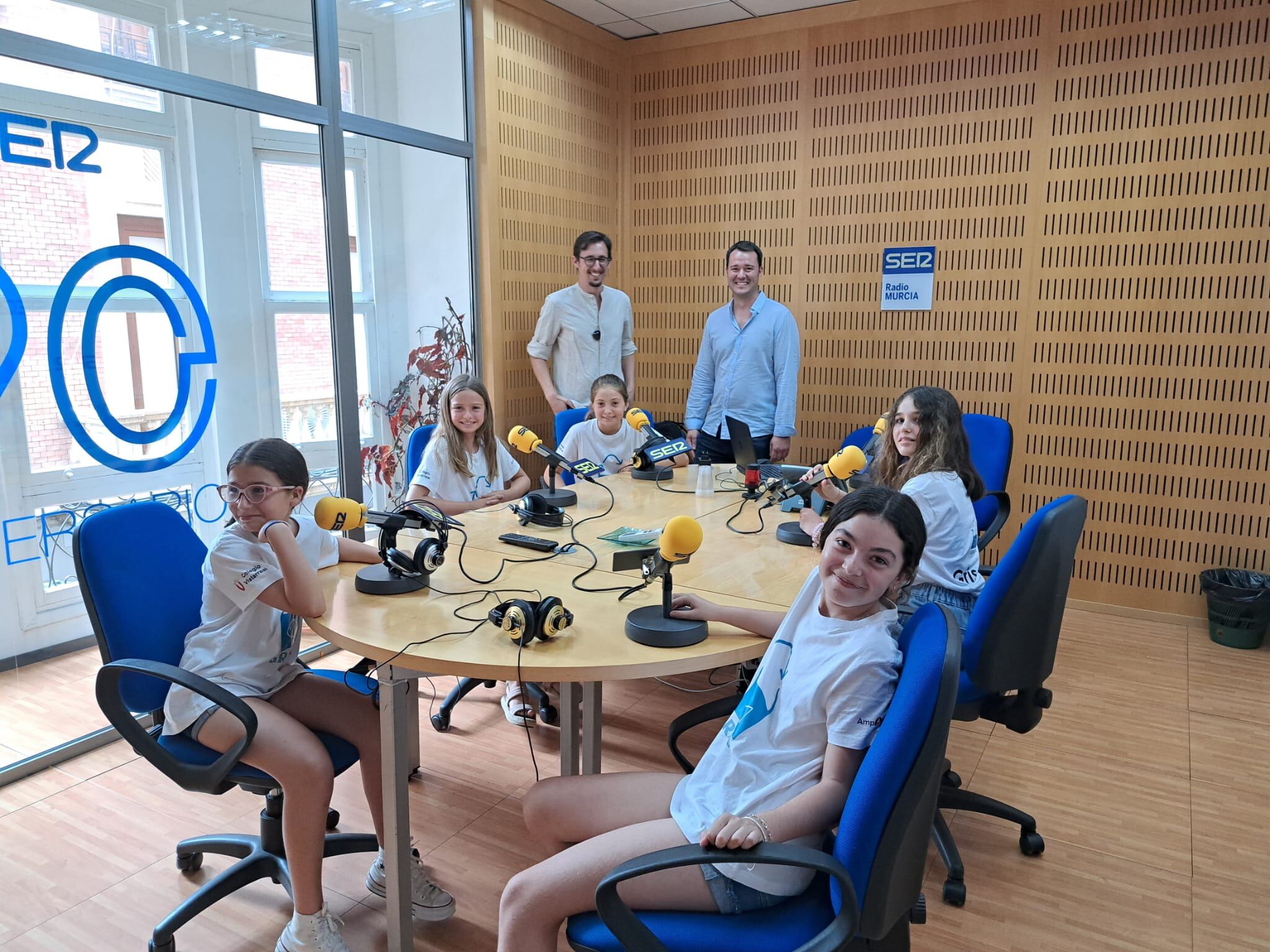 Las chicas de TechnovationGirls acompañadas de sus mentores, Juan Gomariz (izquierda) y Enrique Bernal (derecha) en el estudio central de Radio Murcia