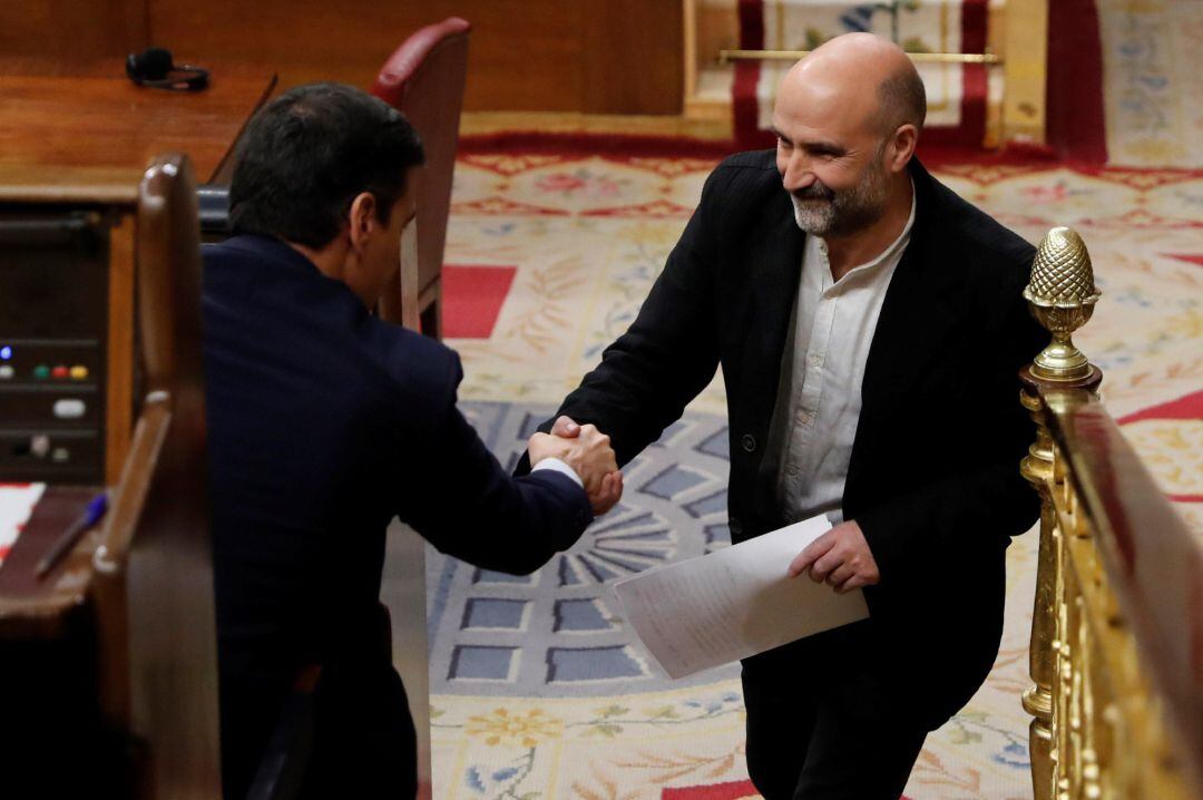 El diputado del BNG, Néstor Rego, saluda al presidente Pedro Sánchez (i) tras su intervención este martes en el Congreso donde se celebra la segunda y definitiva votación para investir presidente del Gobierno al candidato socialista.