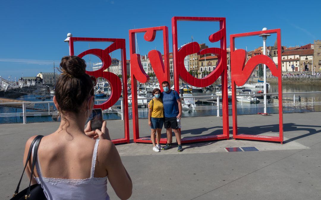 Dos turistas se fotografían en Gijón durante este verano. 