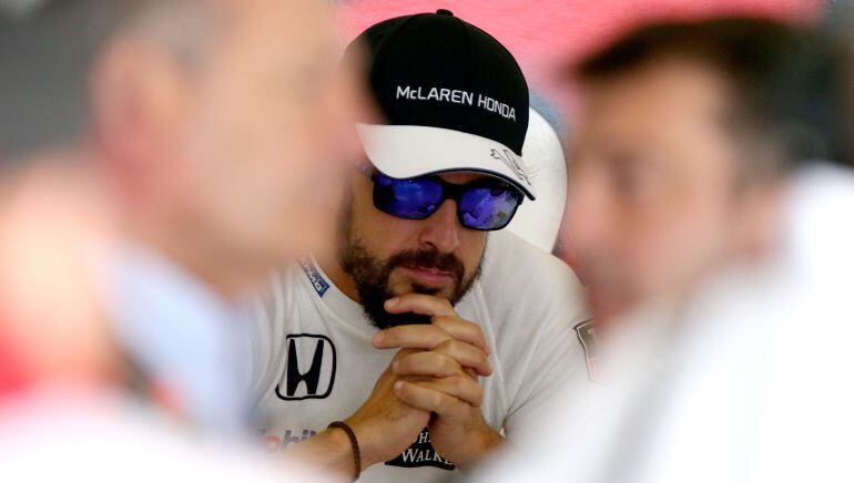 Fernando Alonso, en el box de McLaren-Honda detrás de Ron Dennis, máximo responsable de la escudería.