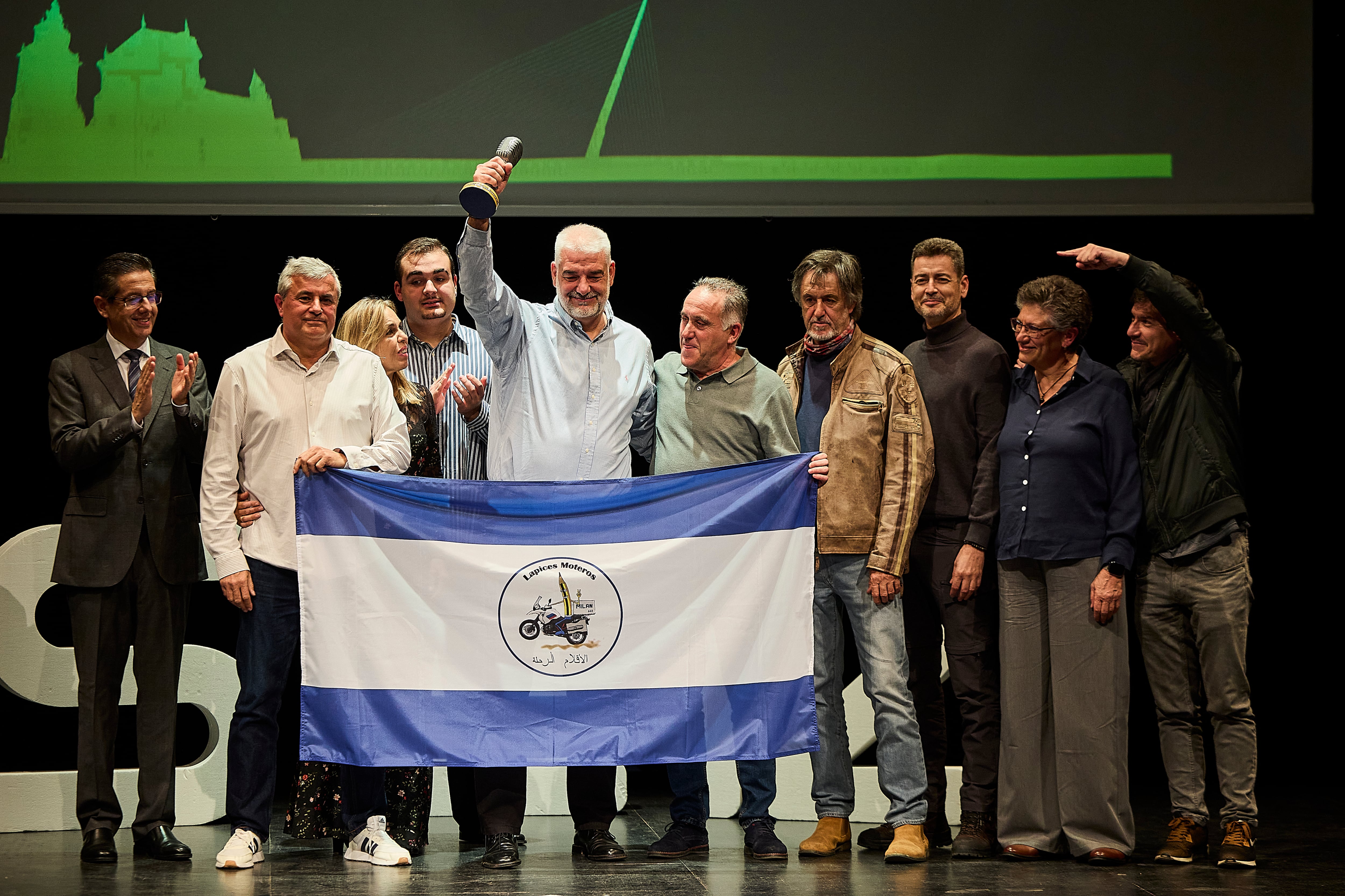 Miembros de Lápices Moteros celebran sobre el escenario del Teatro Victoria