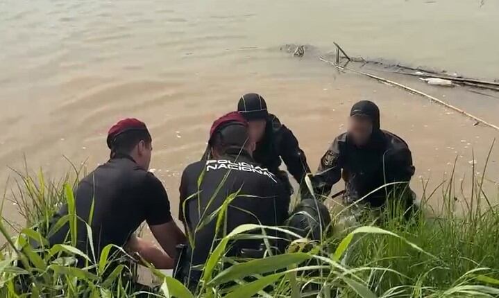 Los agentes de la Policía Nacional rescatan el cadáver del joven desaparecido en el río Turia, en Manises