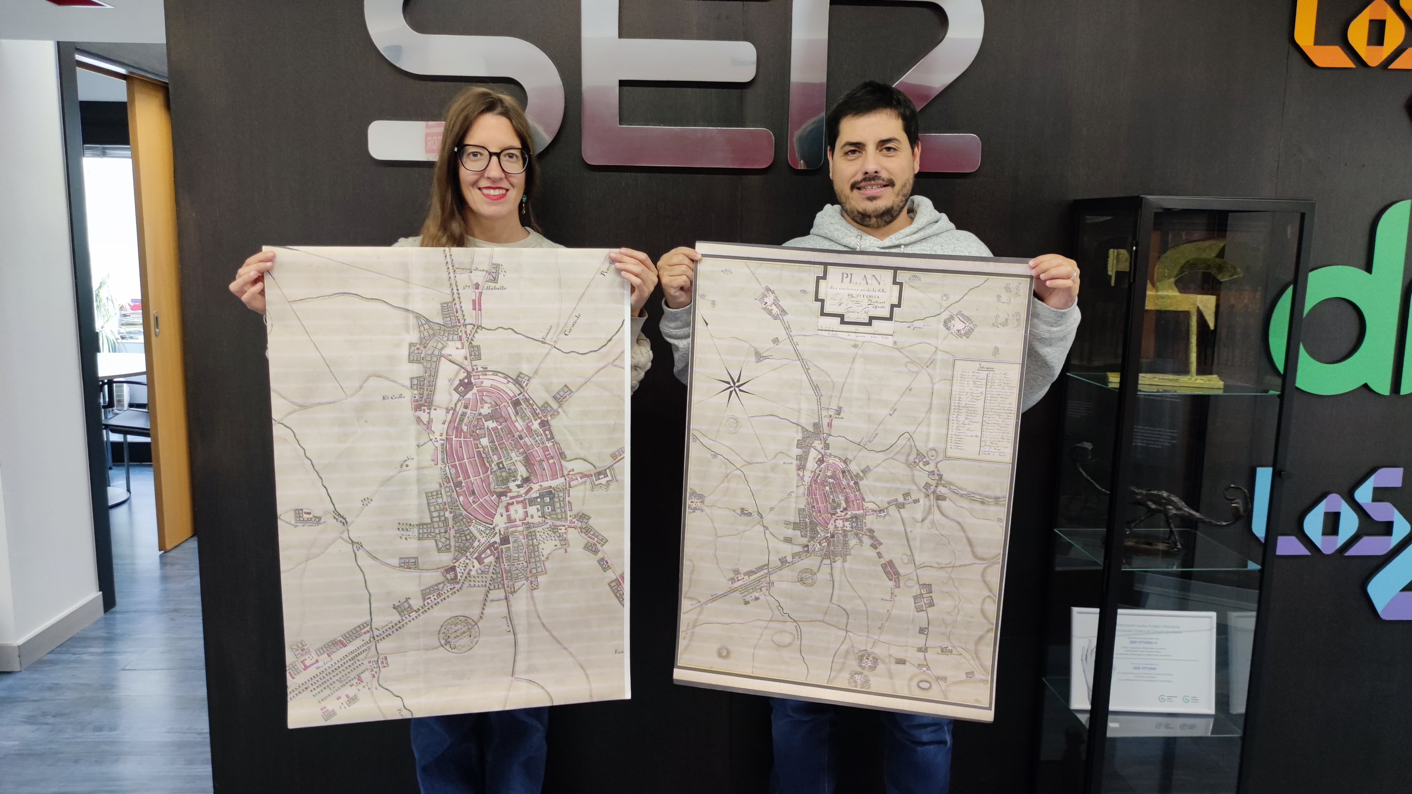 Naiara López de Munain y Jon Dos Santos, de Ser Vitoria, muestran el plano de Vitoria de 1812 y una ampliación del casco urbano de la ciudad