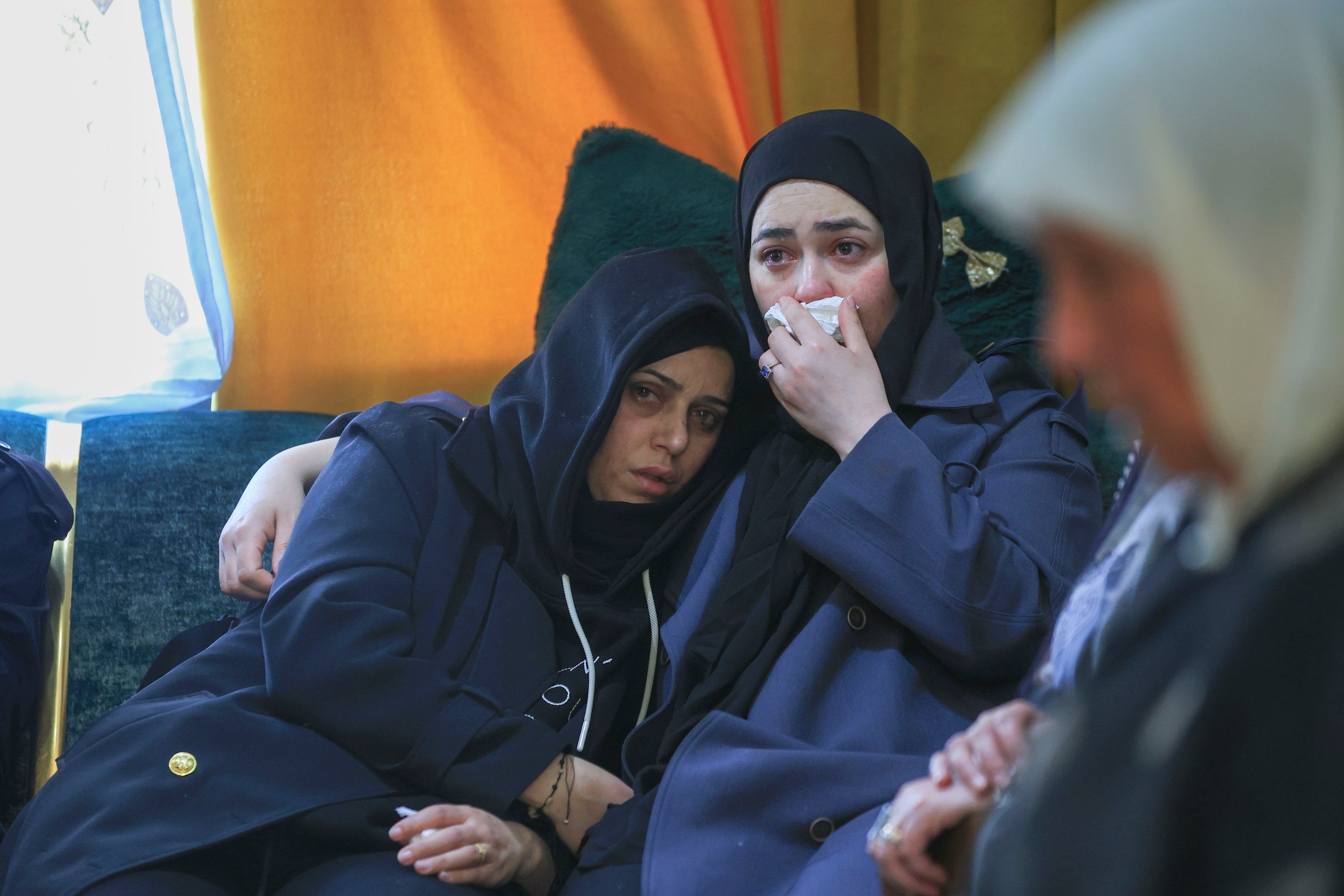 BEIT AWA (GAZA Y CISJORDANIA), 19/03/2026.- Cientos de palestinos despidieron este jueves a tres de las cuatro mujeres que murieron el miércoles por la noche en una aldea de Cisjordania por un impacto de un misil de racimo iraní, alcanzadas cuando estaban en una caseta prefabricada que servía de salón de belleza femenino. Tres ambulancias con tres de los cadáveres de las mujeres abrieron, con las sirenas encendidas, una caravana de decenas de coches desde el Hospital de Dura hasta el cementerio de la aldea de Beit Awa, donde cientos de palestinos asistieron al entierro. EFE/ Magda Gibelli