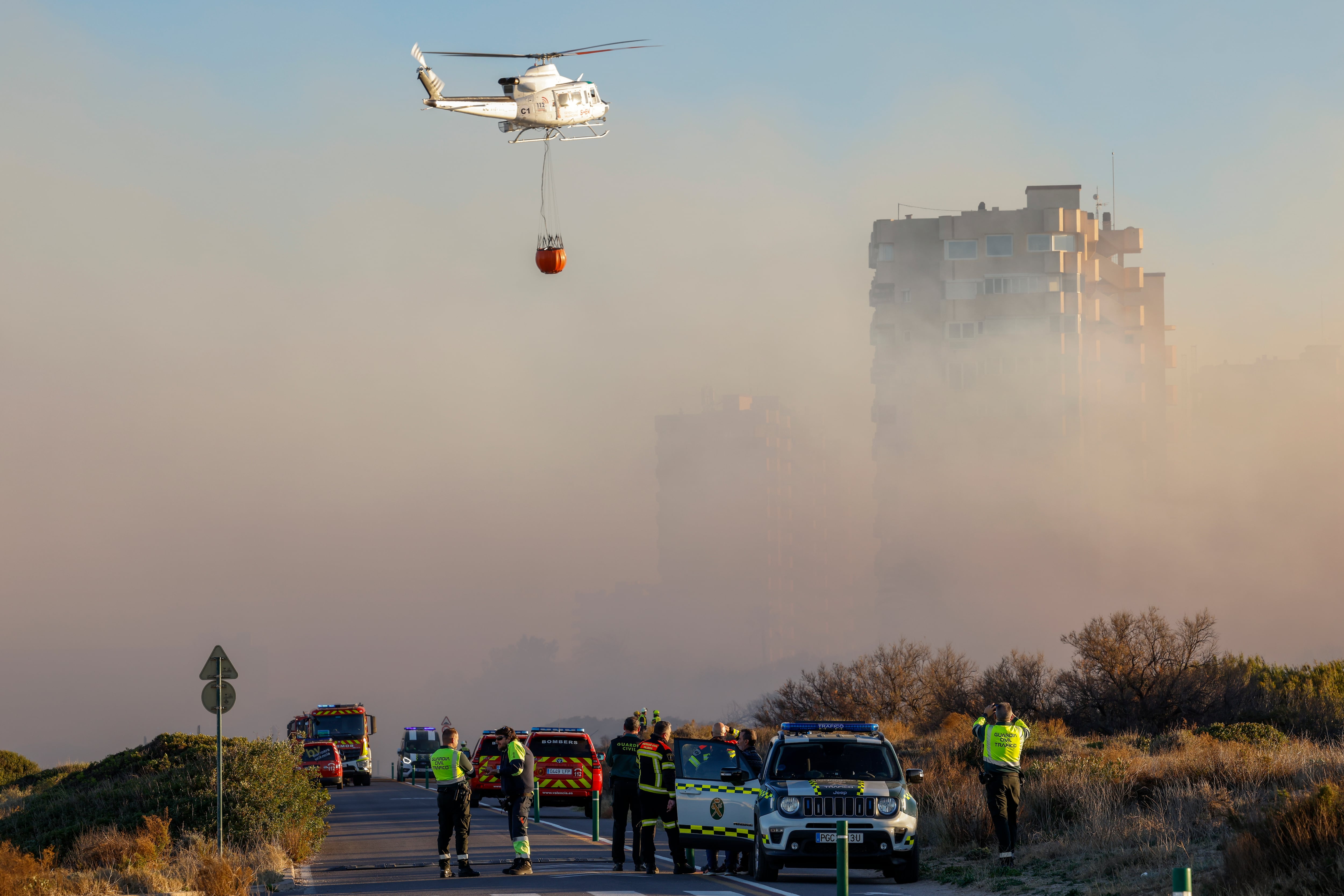 Un helicóptero trabaja en las labores de extinción del incendio forestal declarado a primera hora de la tarde de este lunes en El Saler,