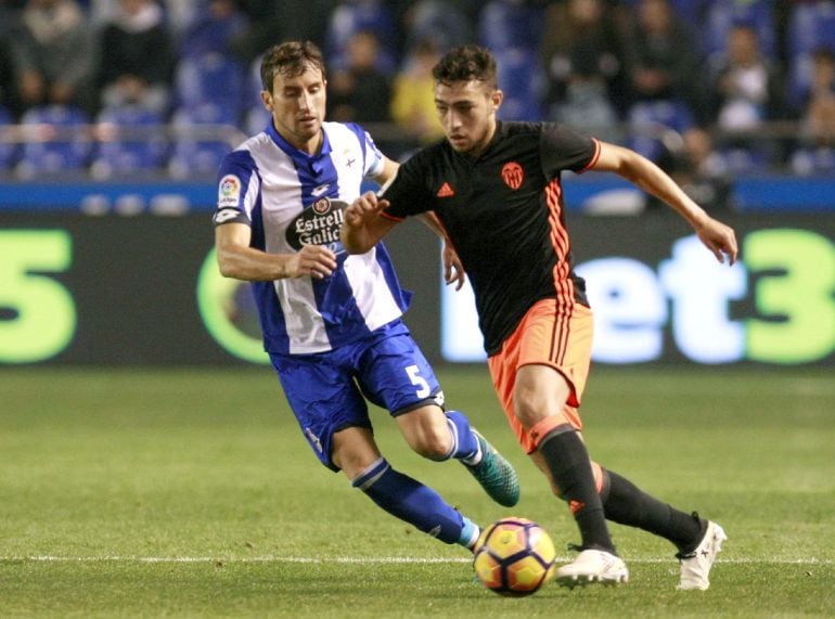 El defensa del Valencia CF Munir El Haddadi (d) se escapa de Pedro Mosquera, del Deportivo de La Coruña, durante el partido de la décima jornada de Liga en Primera División disputado en el estadio Riazor, en A Coruña.