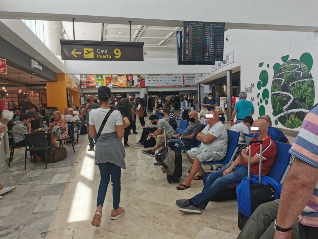 Numerosos turistas extranjeros sin apenas distancia y algunos sin mascarilla o mal colocada, este domingo en la sala de embarque del aeropuerto César Manrique Lanzarote.