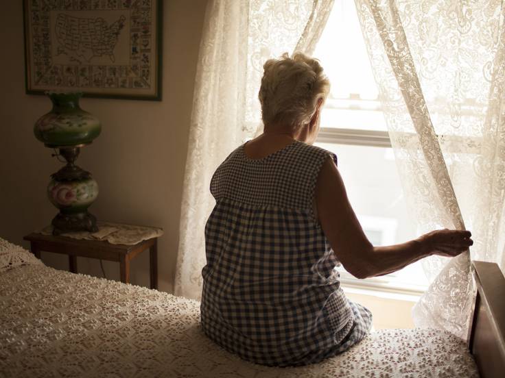 Una anciana mirando por la ventana