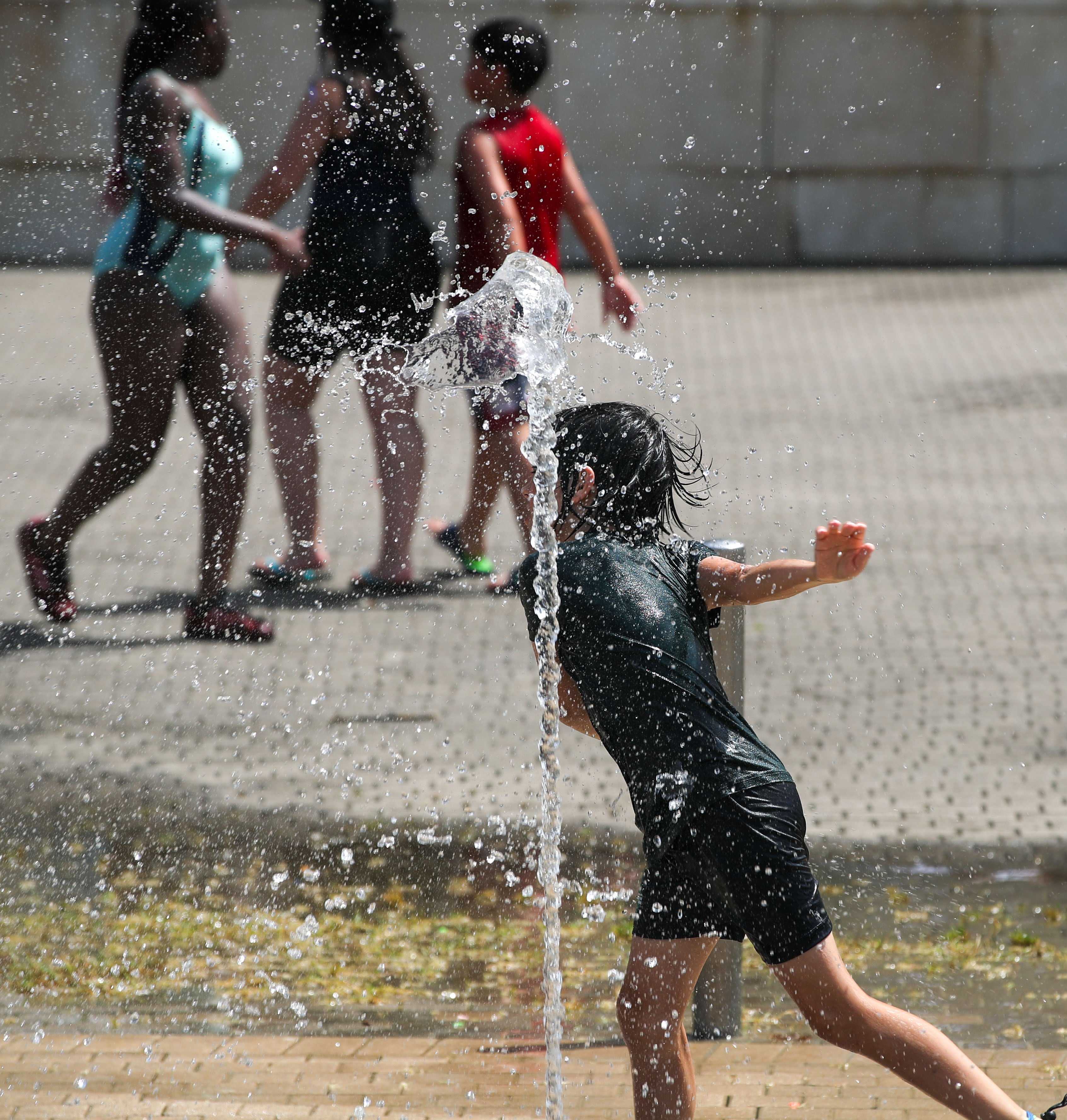 GRAFCAV6569. BILBAO, 17/06/2022.-Un niño juega con agua para refrescarse este viernes en Bilbao. La ola de calor, que afecta a casi toda España y deja ya récords de máximas absolutas en el mes de junio, se recrudece este viernes con una nueva subida de temperaturas que superarán los 35 grados en amplias zonas de la Península y Baleares.EFE/Luis Tejido.
