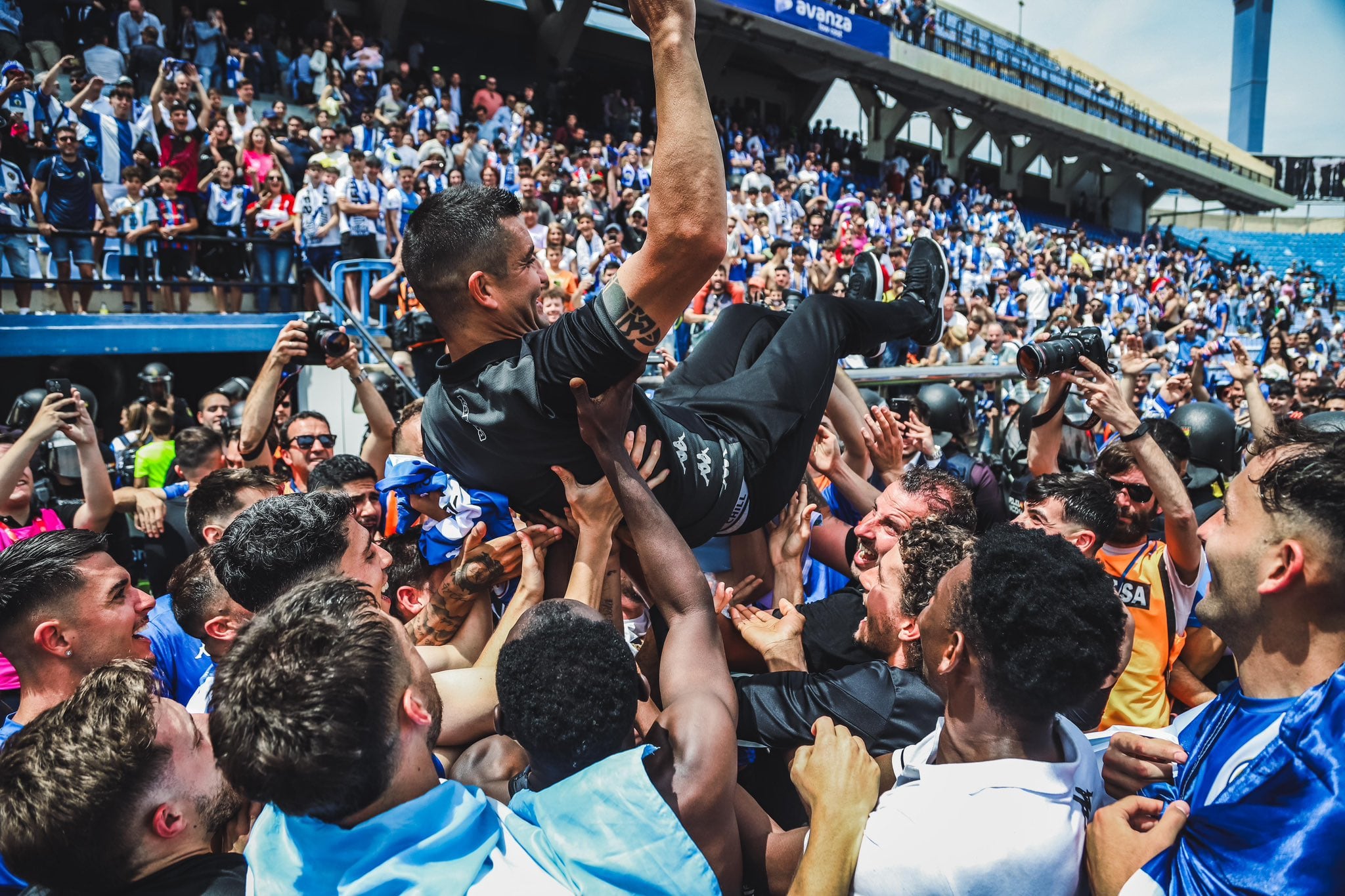 Rubén Torrecilla es manteado por aficionados y jugadores tras conseguir el ascenso. Foto: Hércules CF