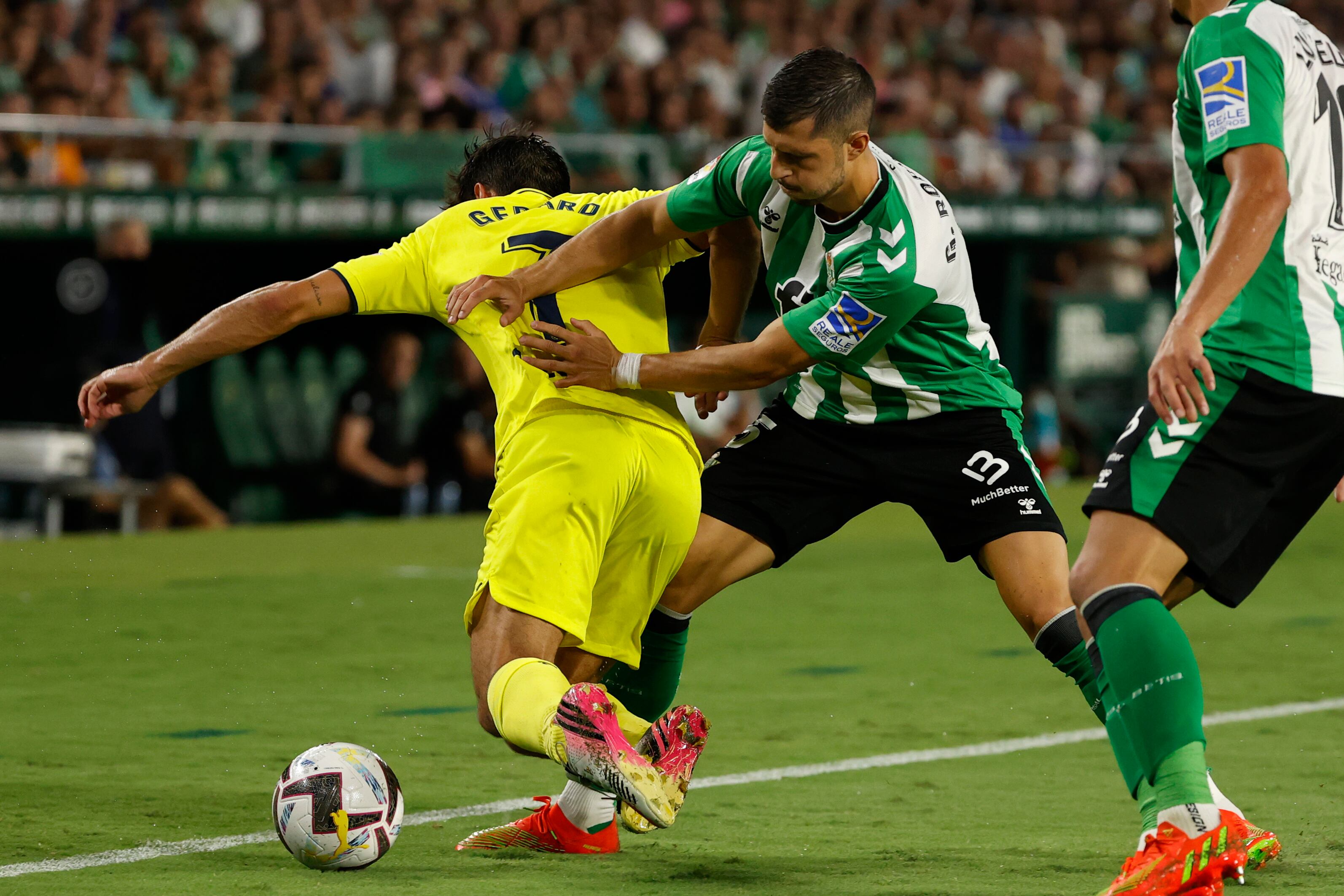 SEVILLA, 11/09/2022.- El delantero del Villarreal Gerard Moreno (i) cae tras luchar con el argentino Guido Rodríguez, del Betis, durante el partido de la quinta jornada de Liga en Primera División que Real Betis y Villarreal CF disputan hoy domingo en el estadio Benito Villamarín, en Sevilla. EFE/ Julio Muñoz