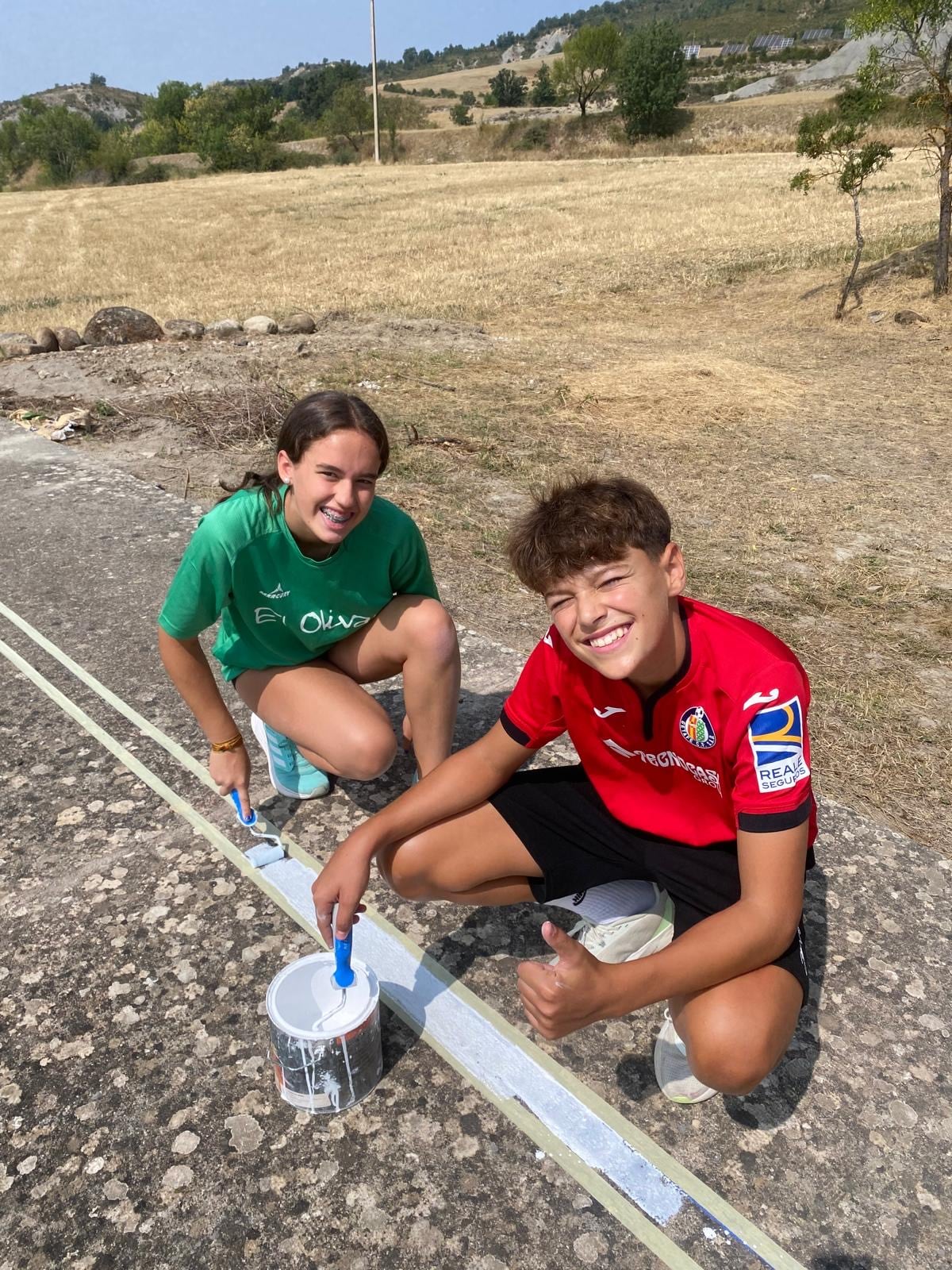 Pintar las líneas del campo ha sido una de las múltiples tareas que han realizado los jóvenes durante estos días