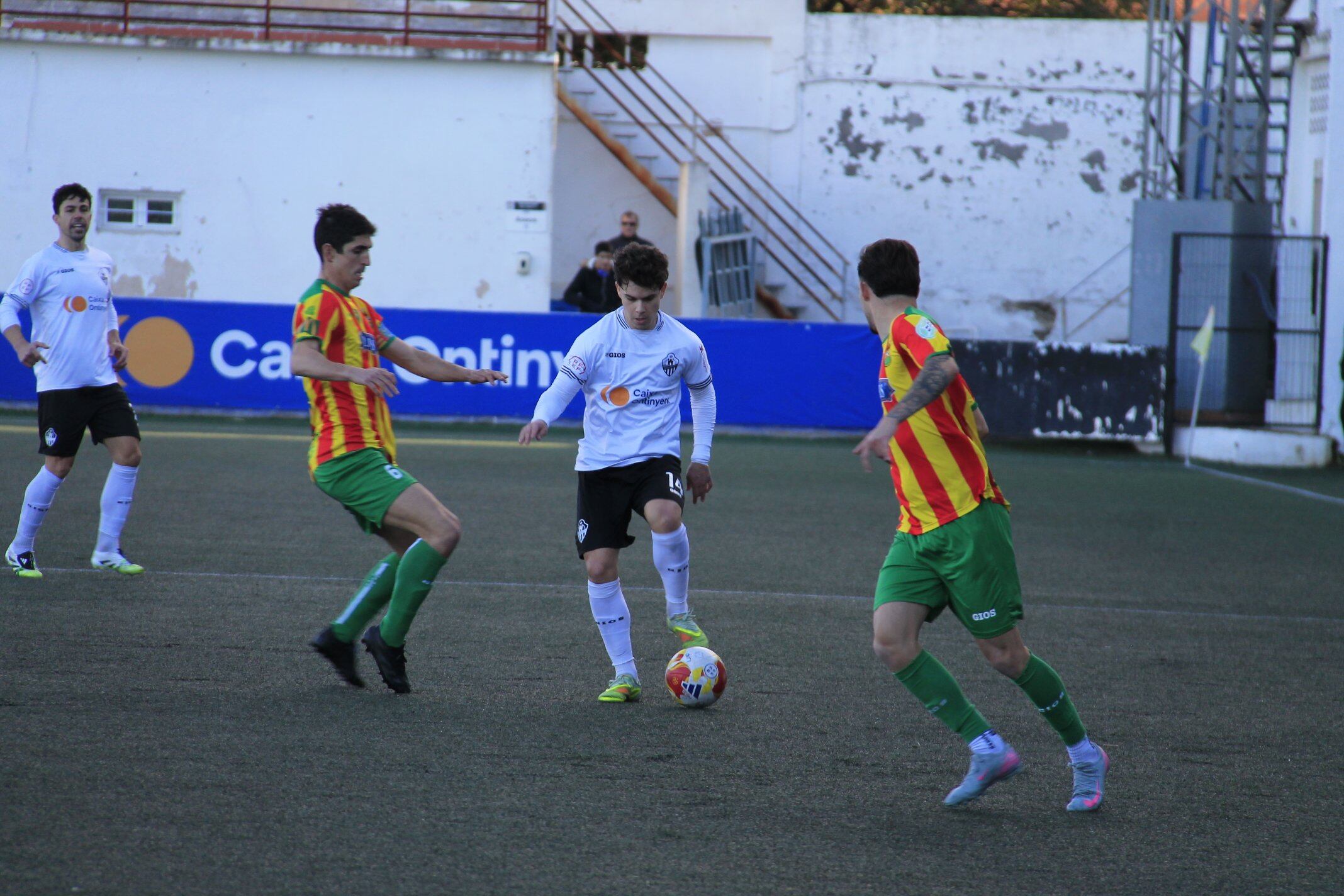 Jorge García intenta zafarse de la presión del Jove Español durante una acción de la primera parte en El Clariano