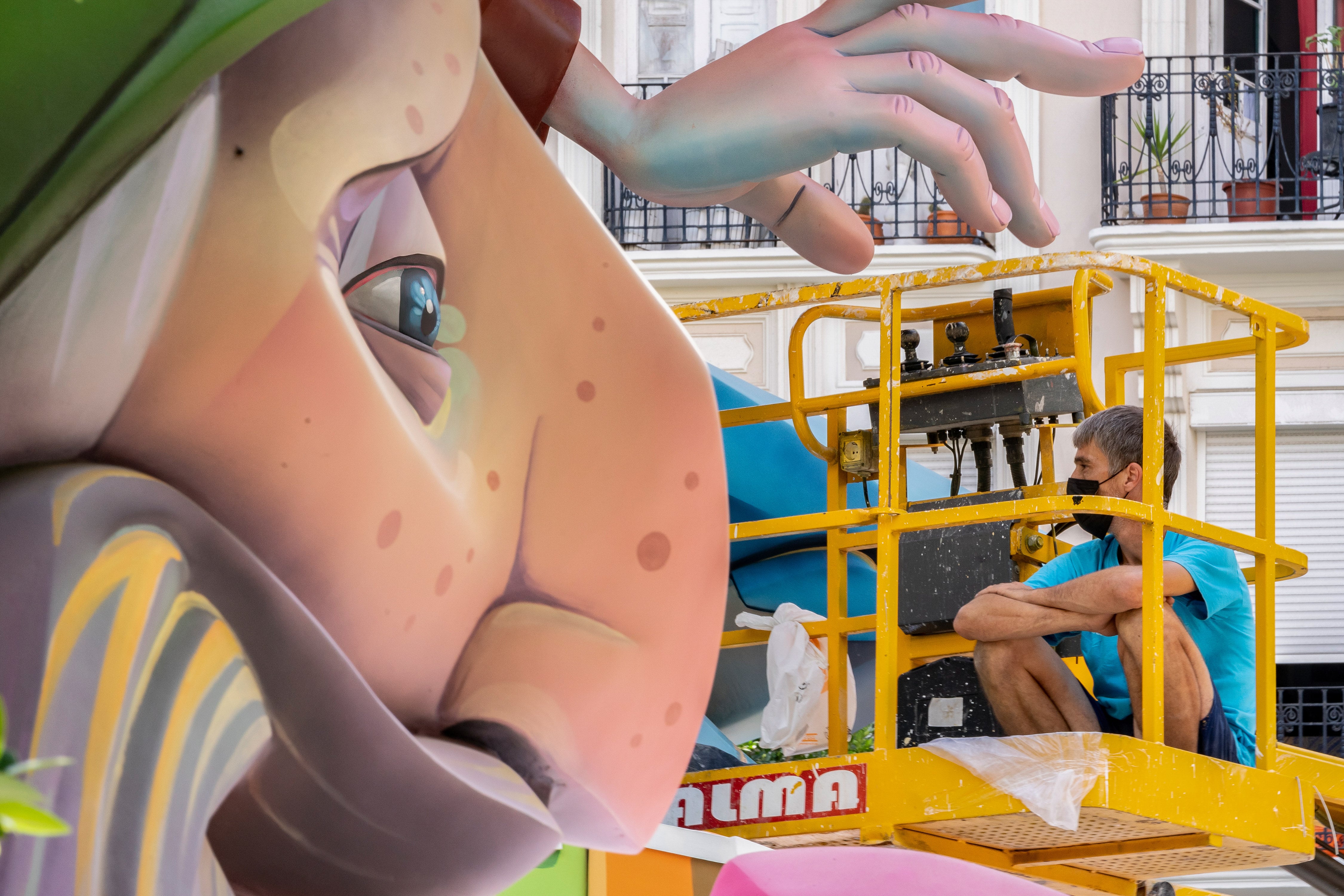 Un trabajador esperando en un elevador en una plantà de Fallas