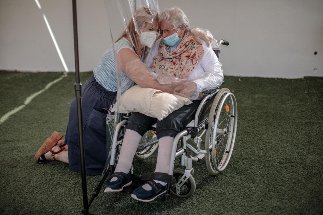 Una interna en una residencia de mayores abraza a su hija a través de un plástico habilitado para que los familiares se puedan dar su primer abrazo desde hace tres meses