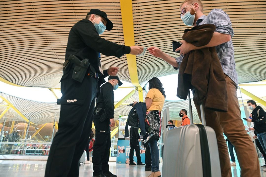 Agentes de la Policía Nacional controlan el acceso a la T-4 del Aeropuerto Adolfo Suárez Madrid-Barajas, hoy viernes, para vigilar el cumplimiento de las restricciones a la movilidad impuestas por el estado de alarma que ha decretado el Gobierno.