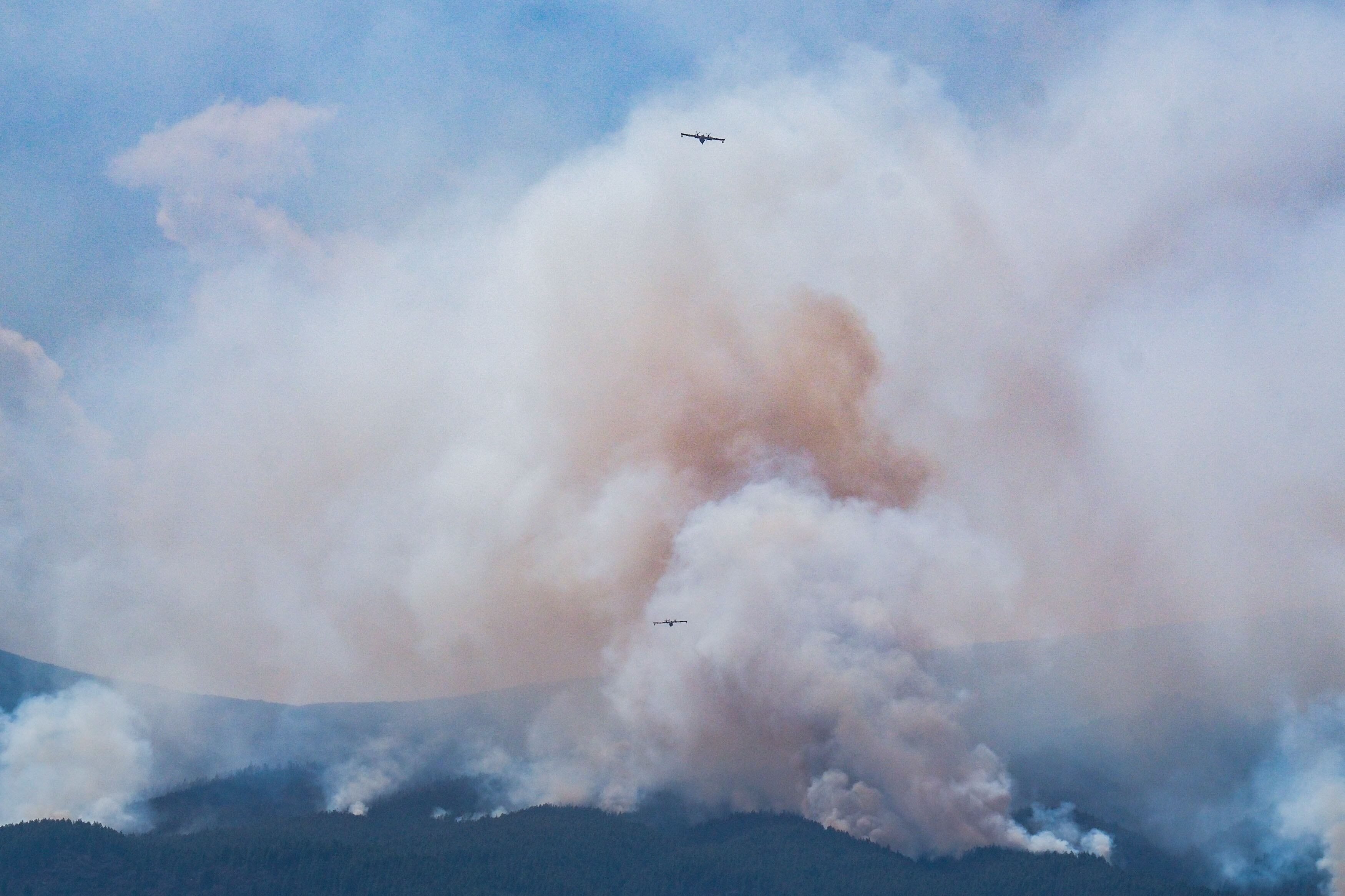 Dos hidroaviones luchan contra el incendio forestal que afecta a la isla de Tenerife este lunes en Güimar, uno de los municipios afectados.