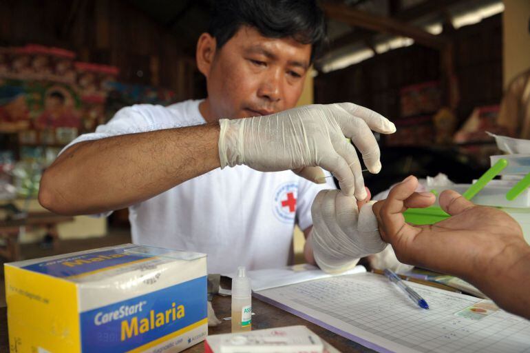 TO GO WITH AFP STORY BY ALICE RITCHIE (FILES) -- A file picture taken on July 5, 2012 shows a village malaria worker carrying out a blood test at his home in Pailin province, some 350 kilometers northwest of Phnom Penh. The number of people dying from malaria has almost halved since 2000, although progress in west Africa risks being reversed by the Ebola outbreak, the World Health Organization said on December 9, 2014. Global mortality rates fell by 47 percent between 2000 and 2013 and by 53 percent in children under the age of five, the WHO said in its annual report on the disease. AFP PHOTO / TANG CHHIN SOTHY