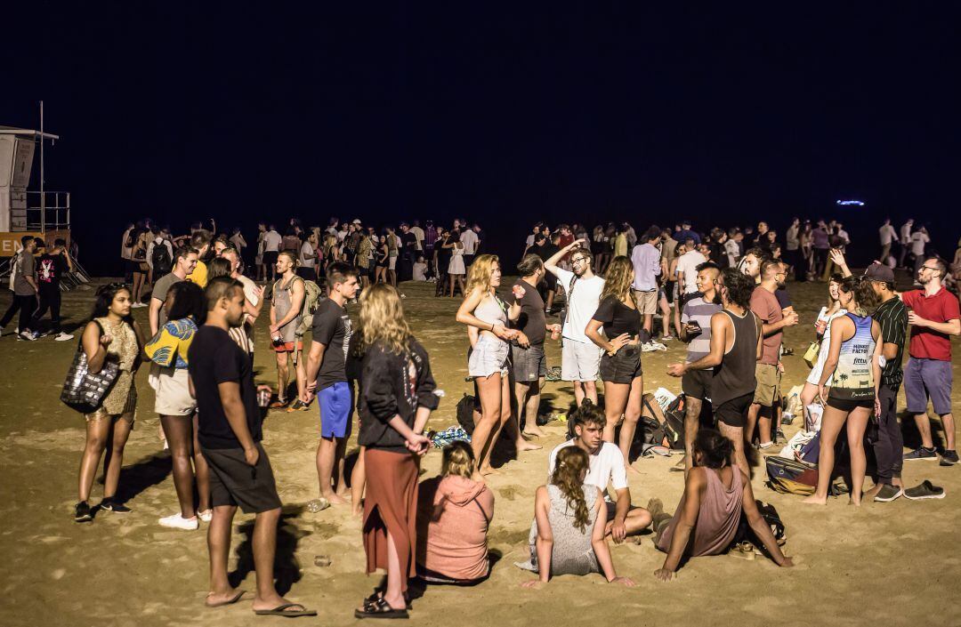 Jóvenes haciendo botellón en la playa de la Barceloneta