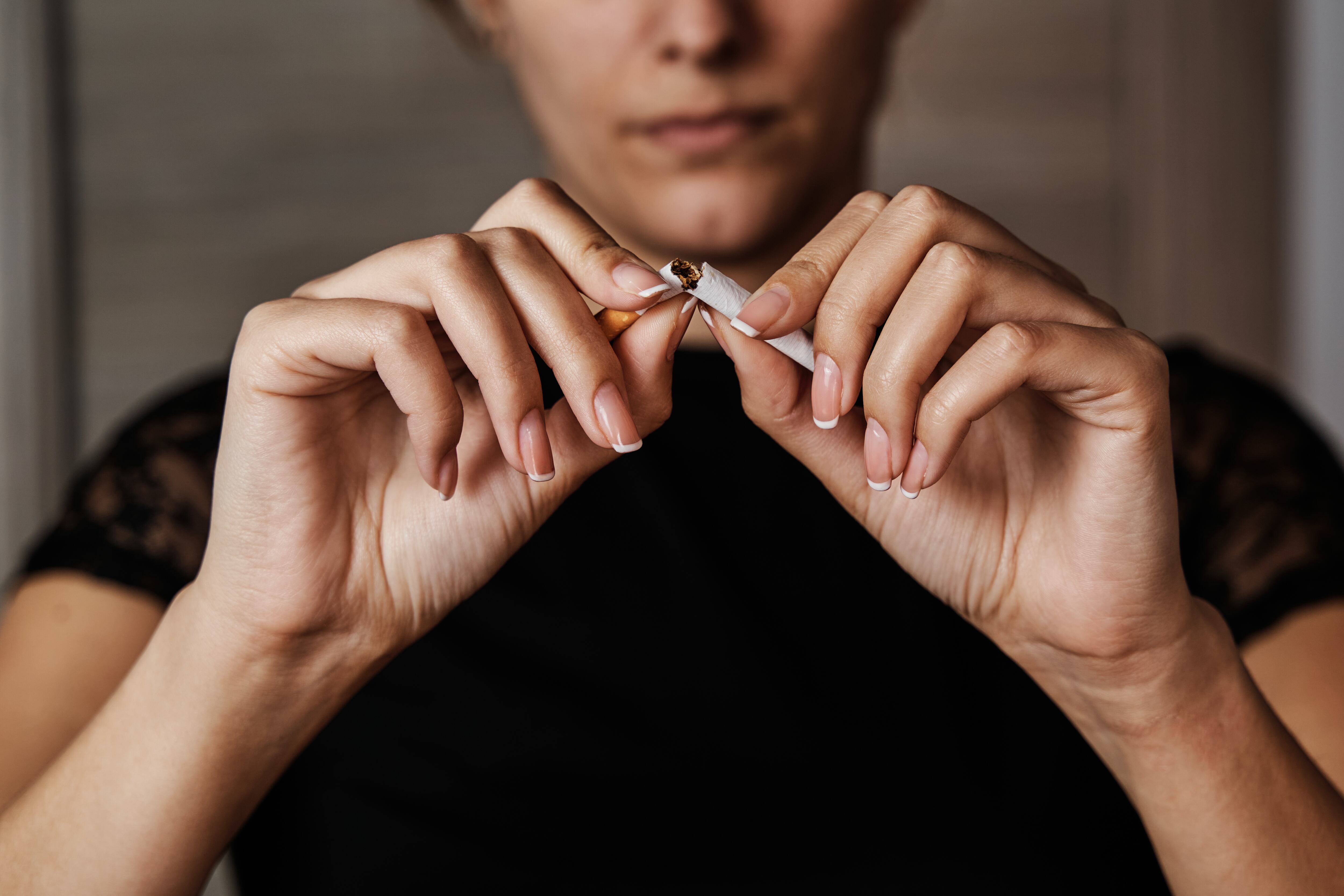 Una mujer rompe un cigarro.