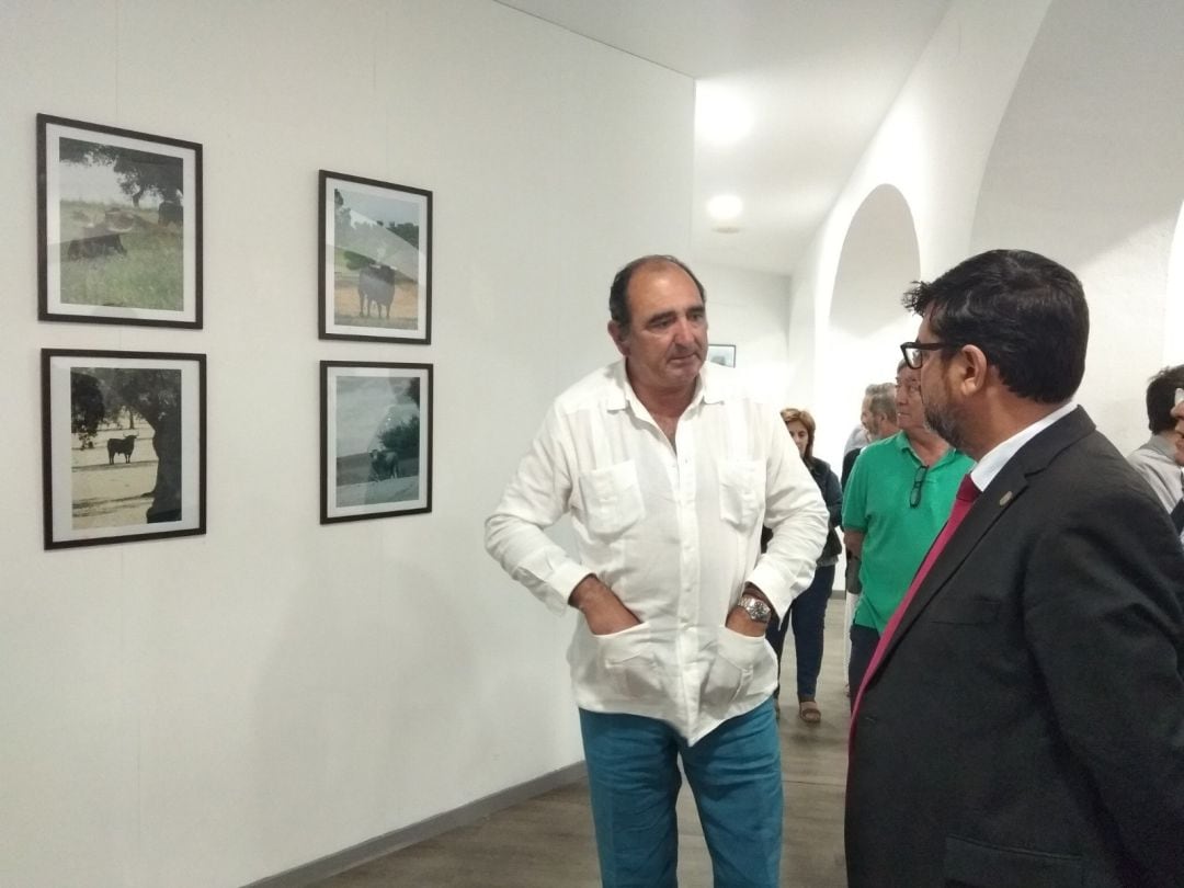 Leopoldo Sainz de la Maza departe con el alcalde de Utrera, José María Villalobos, durante la inauguración de su exposición fotográfica con el toro como protagonista 