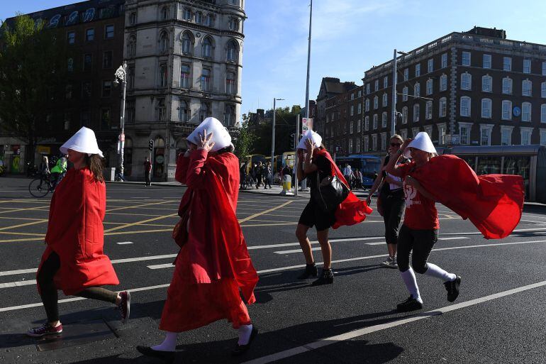  activistas en favor del aborto y la libertad de decidir, disfrazados como la serie &quot;el cuento de la criada&quot; por las calles de dublin.