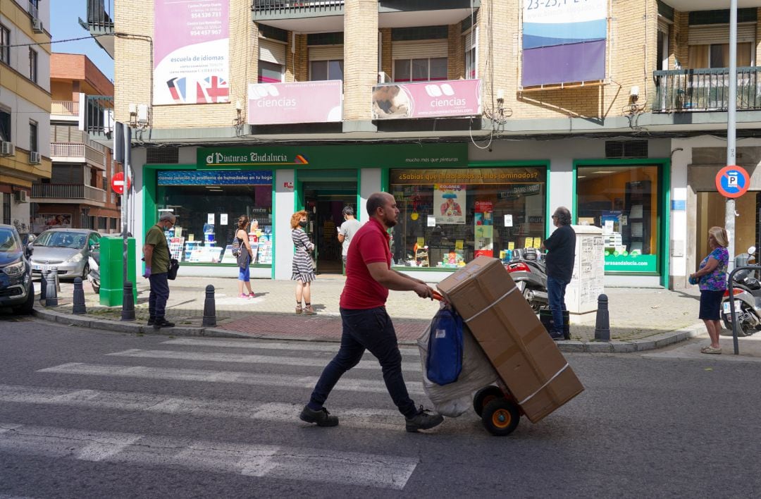 Ciudadanos guardando cola en una tienda de pinturas durante el tercer día de la desescalada del Gobierno y el inicio de la semana octava del estado de alarma decretada por la crisis del coronavirus, en Sevilla 