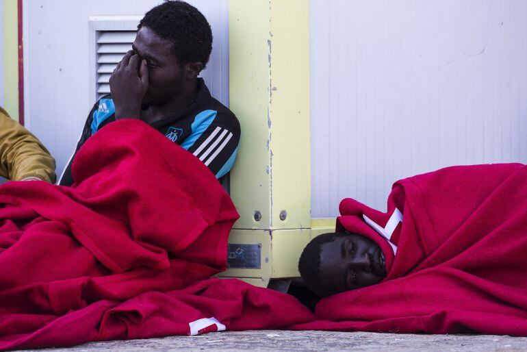 GRA406. MÁLAGA, 29/10/2015.- Varios de los 15 inmigrantes rescatados con vida de la patera que naufragó ayer tras zarpar desde una playa de Alhucemas (Marruecos) y que han sido trasladados a bordo de la embarcación &quot;Guardamar Polimnia Santa Cruz de Tenerife&quot; hasta el puerto de Málaga, donde esperan ser atendidos por la Cruz Roja. Los cadáveres de tres personas han sido encontrados hoy por los servicios de salvamento que participan en la búsqueda en el mar de los 38 desaparecidos tras el naufragio de esta patera. EFE/Jorge Zapata