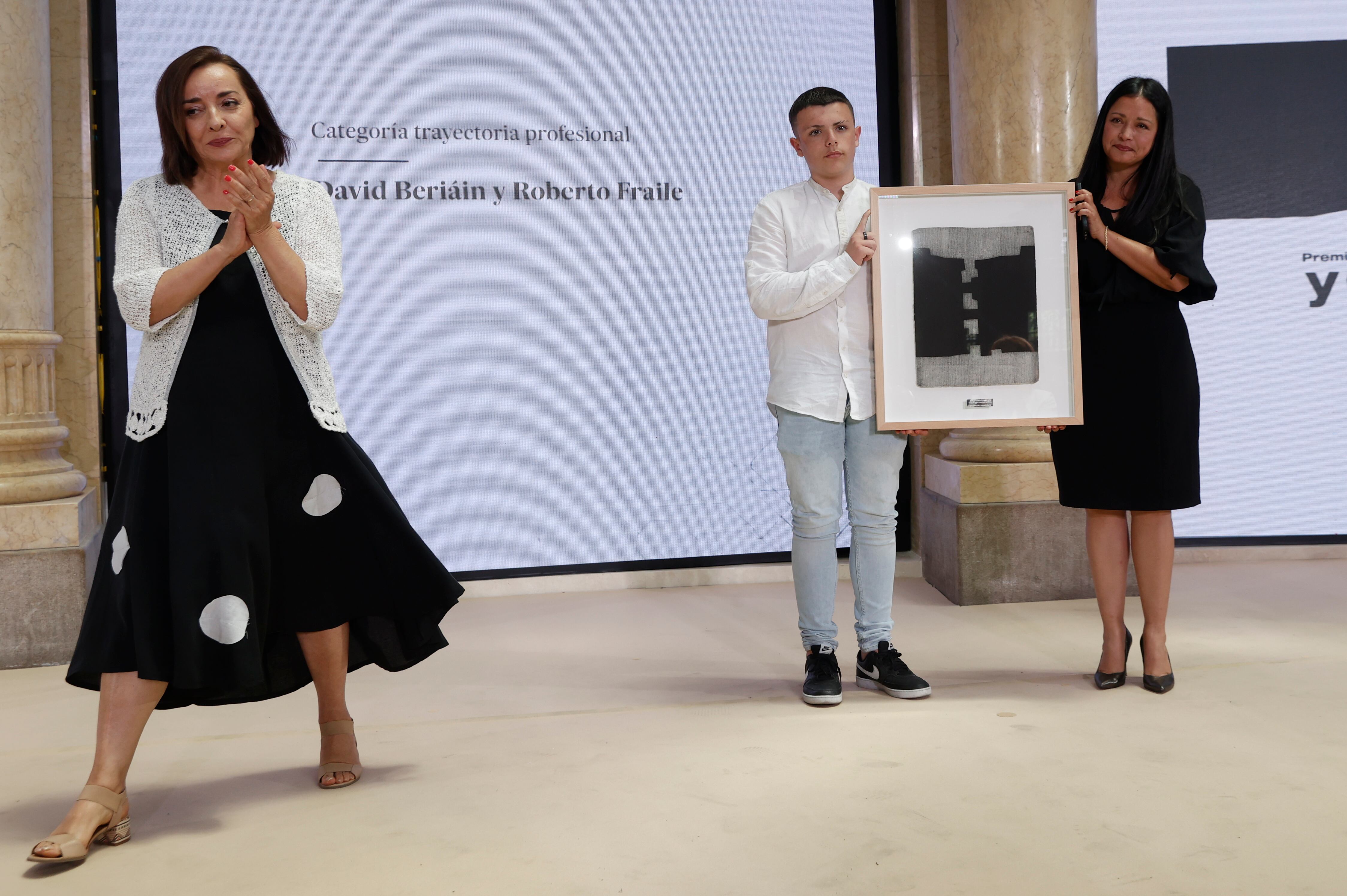 Rosaura, mujer de David Beriaín y el hijo de Roberto Fraile , recogen el premio Ortega y Gasset 2022 a la trayectoria profesional ante la directora de El País, Pepa Bueno (i) ,en el Palacio de las Comunicaciones de Valencia.