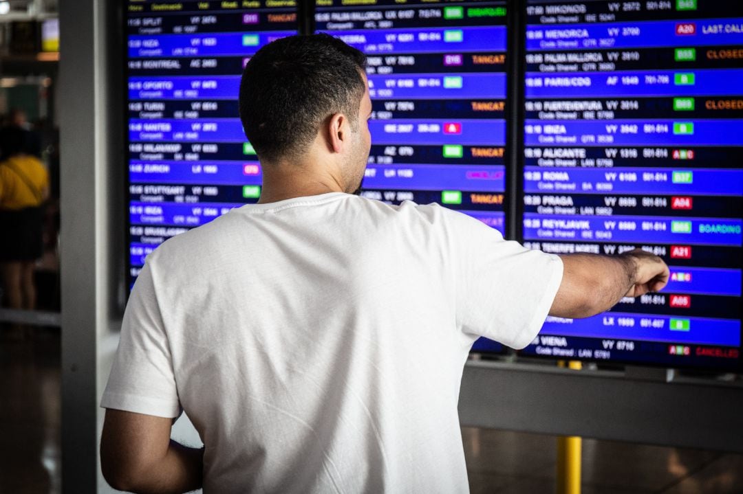 Un hombre mira el panel de información de los vuelos de salida del  Aeropuerto &#039;Josep Tarradellas Barcelona-El Prat&#039;.