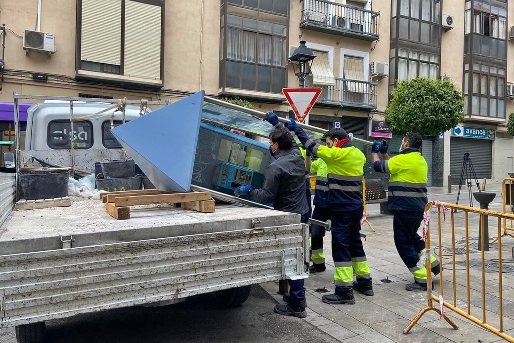 Varios operarios retiran una cabina de teléfono de la capital.