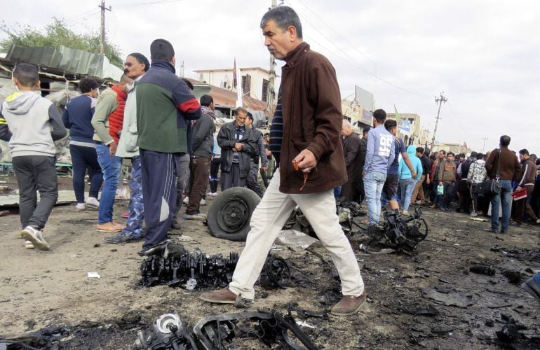  Iraquíes acuden al lugar donde se ha perpetrado un atentado en Sadr en el este de Bagdad.