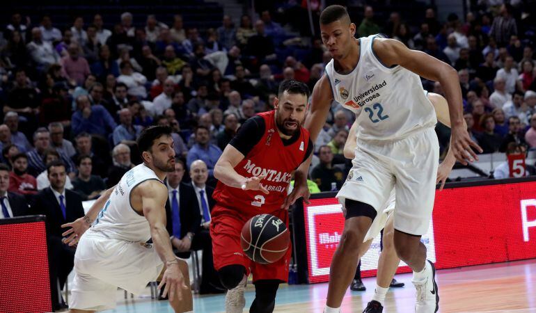 El escolta croata del Fuenlabrada Marko Popovic (c), que anotó 18 puntos, juega un balón entre Facundo Campazzo (i) y Walter Tabares, ambos del Real Madrid, durante el partido de la Liga ACB disputado en el Palacio de los Deportes.