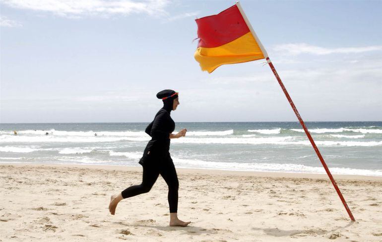 Una mujer usa un &quot;burkini&quot; en una playa