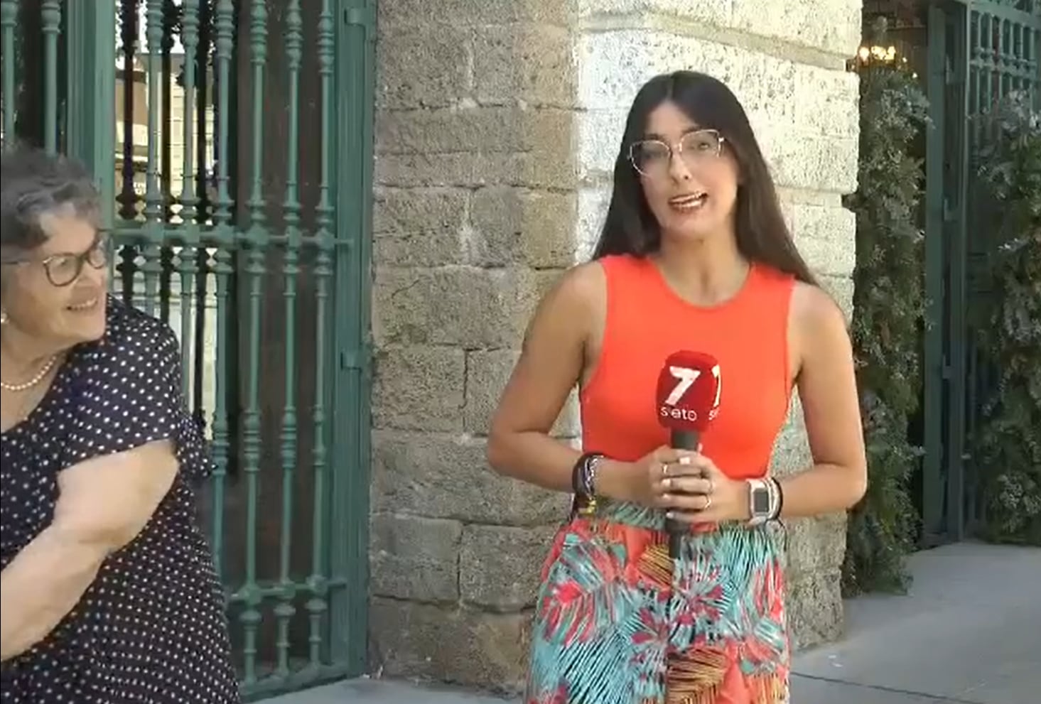 La mujer escucha atentamente la crónica de la reportera.