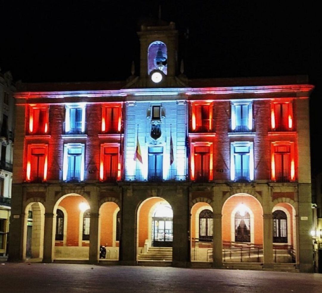 Fachada del Ayuntamiento iluminada de rojo y blanco