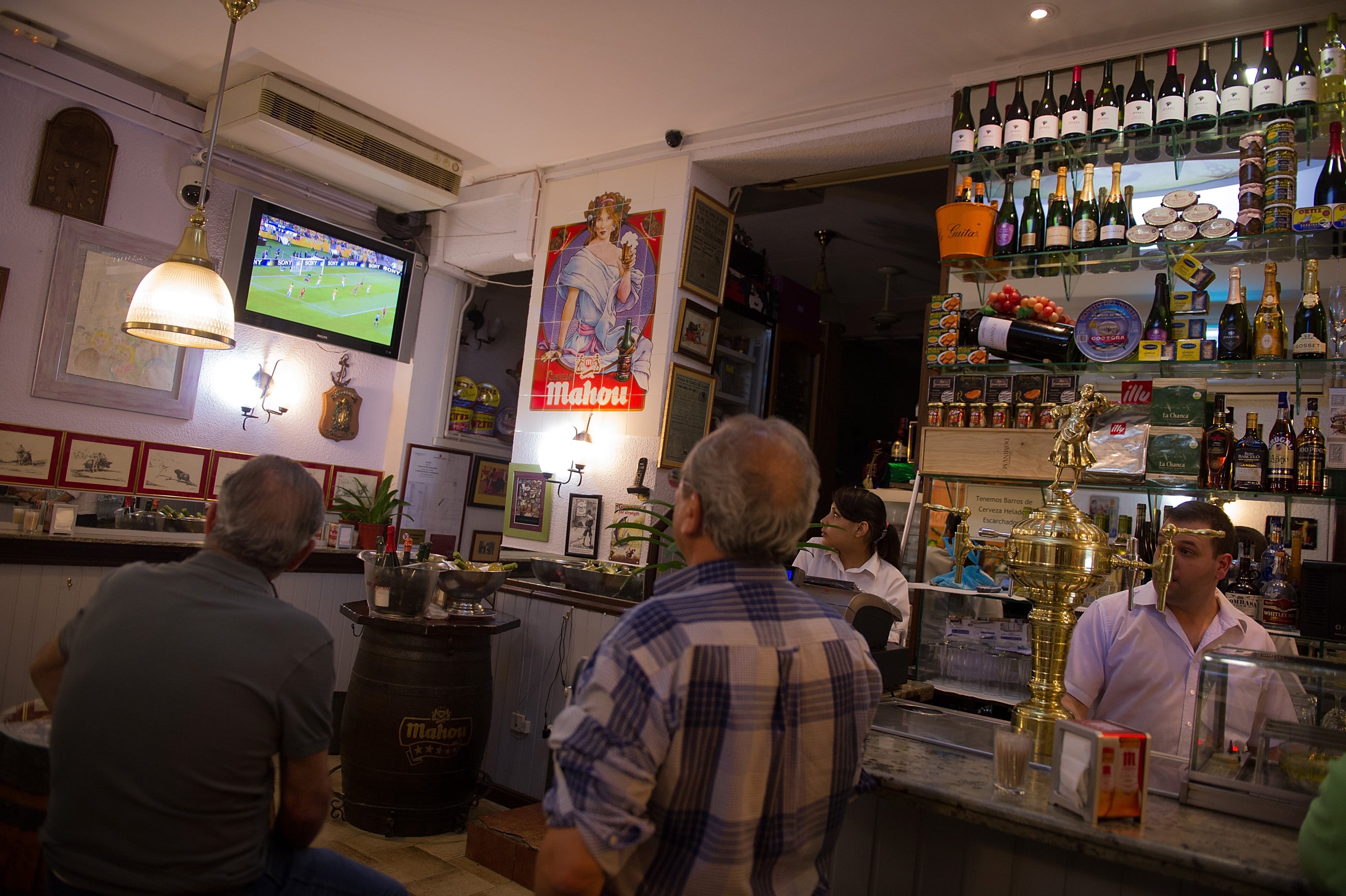 Varias personas ven un partido de fútbol en un bar de Madrid