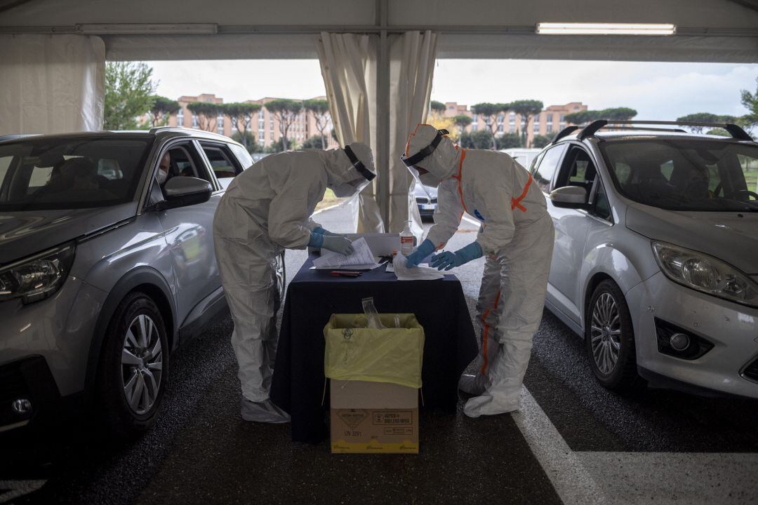 Los trabajadores de salud del ejército italiano recolectan hisopos para verificar si hay COVID-19 en un centro de pruebas en el complejo militar de Cecchignola, durante la emergencia epidemiológica del coronavirus, el 24 de octubre de 2020 en Roma, Italia