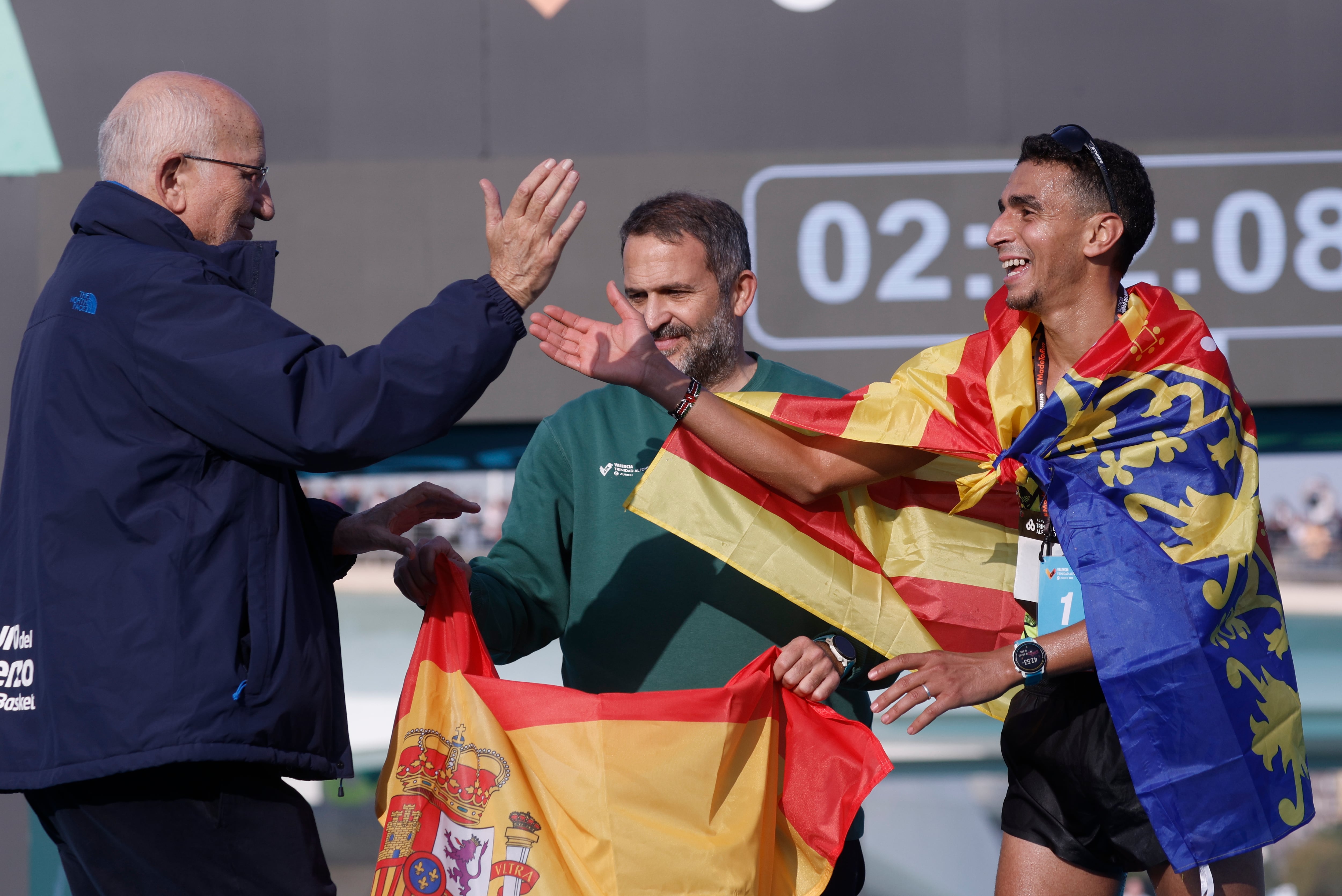 El presidente del Mercadona, Juan Roig (i) felicita al español Ibrahin Chakir (d), tras ser el primer nacional en cruzar la línea de meta durante la cuadragésima cuarta edición de la Maratón Valencia Trinidad Alfonso celebrada este domingo.