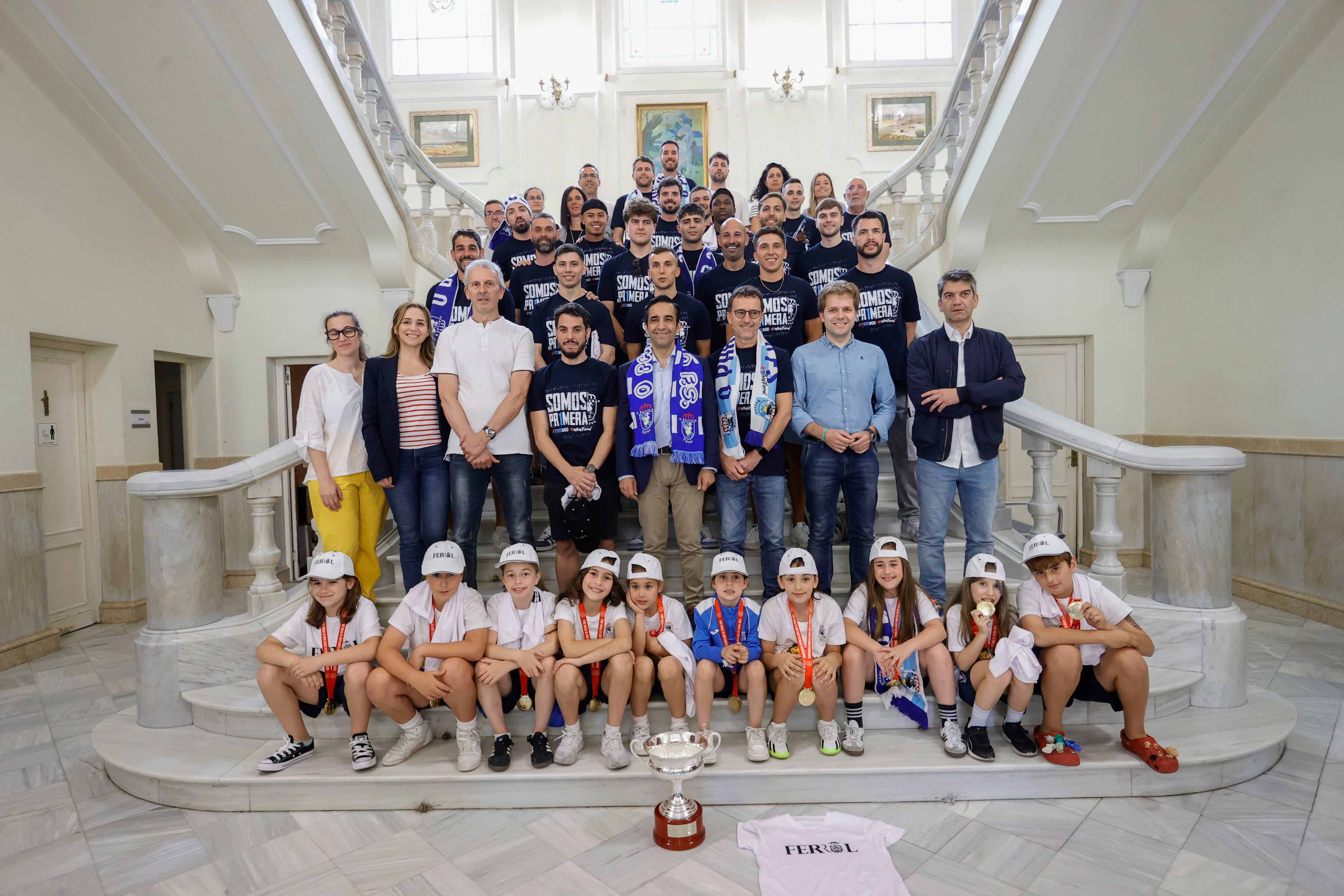 Jugadores y cuerpo técnico de O Parrulo, junto a representantes de la corporación, posan en el Concello de Ferrol este domingo (foto: Kiko Delgado / EFE)