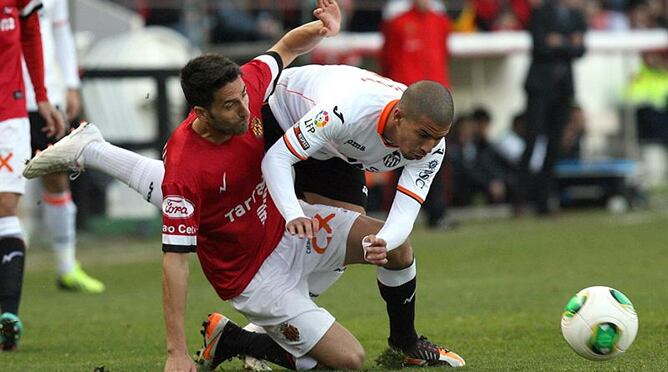 El defensa del Gimnàstic de Tarragona Ramón Verdú lucha un balón con el centrocampista argenilio del Valencia Sofiane Feghouli durante el partido de ida de los dieciseisavos de final de la Copa del Rey, disputado esta tarde en el Nou Estadi de Tarragona