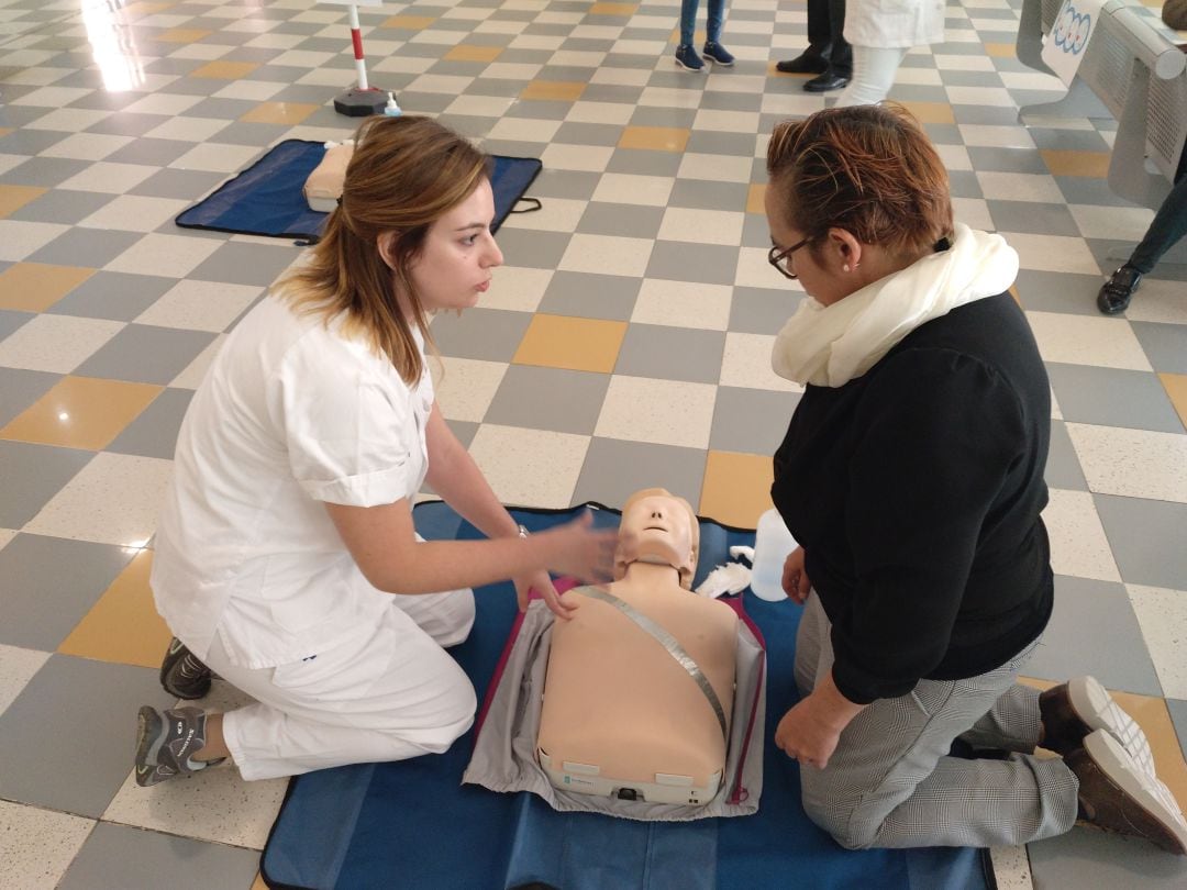 Una profesional de la Sanidad enseña cómo realizar la reanimación cardiaca a una mujer interesada