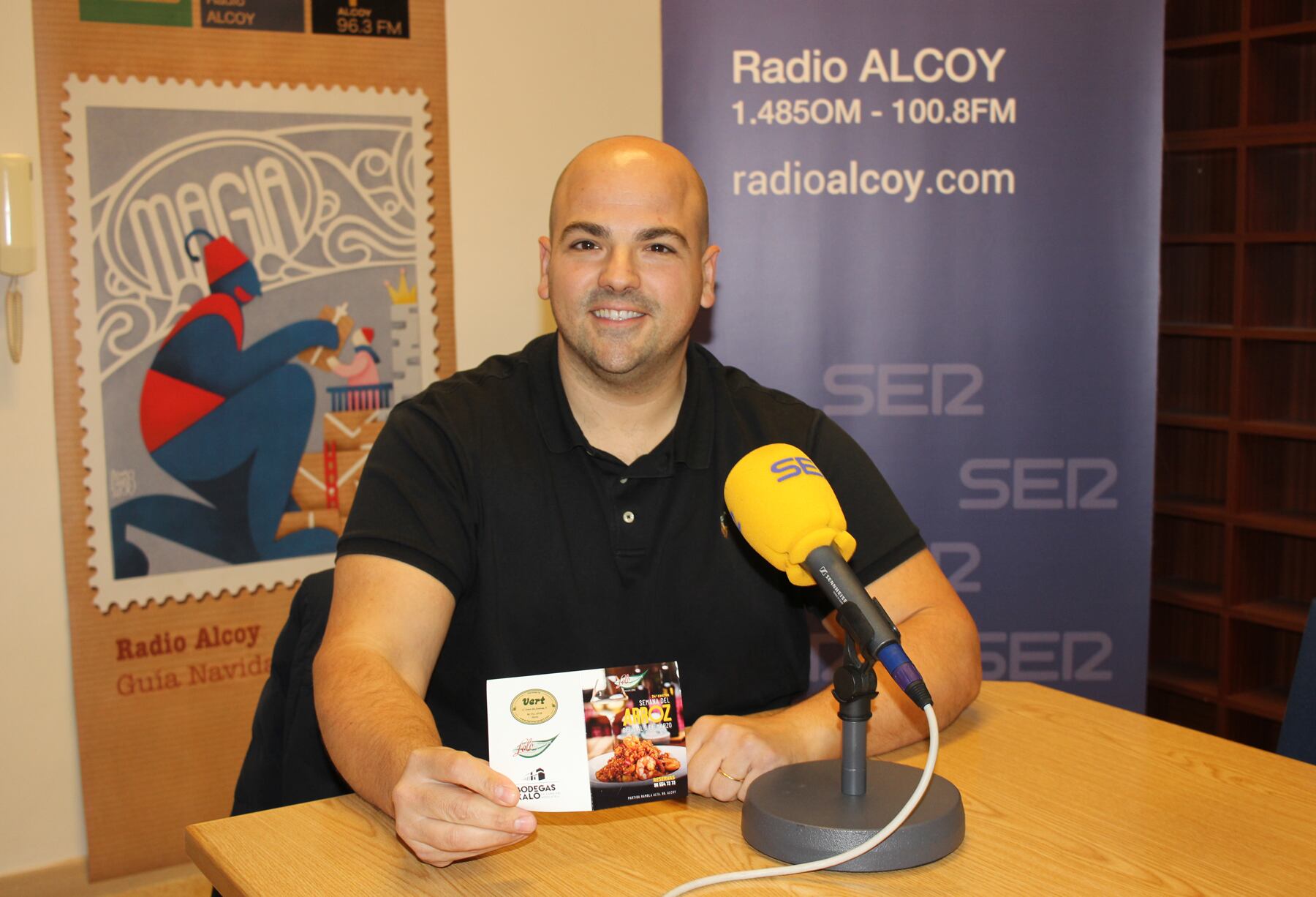 Borja Raduán, en el estudio de Radio Alcoy, muestra uno de los folletos clásicos que anuncia la Semana del Arroz
