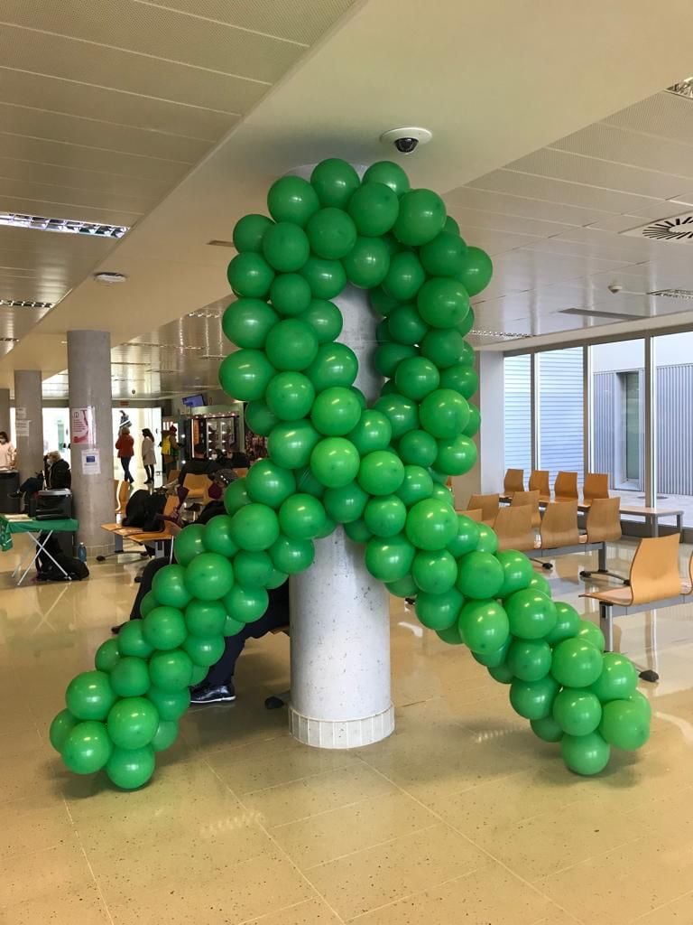 El hospital de Gandia luce una gran lazada verde con motivo del Día Internacional Contra el Cáncer.