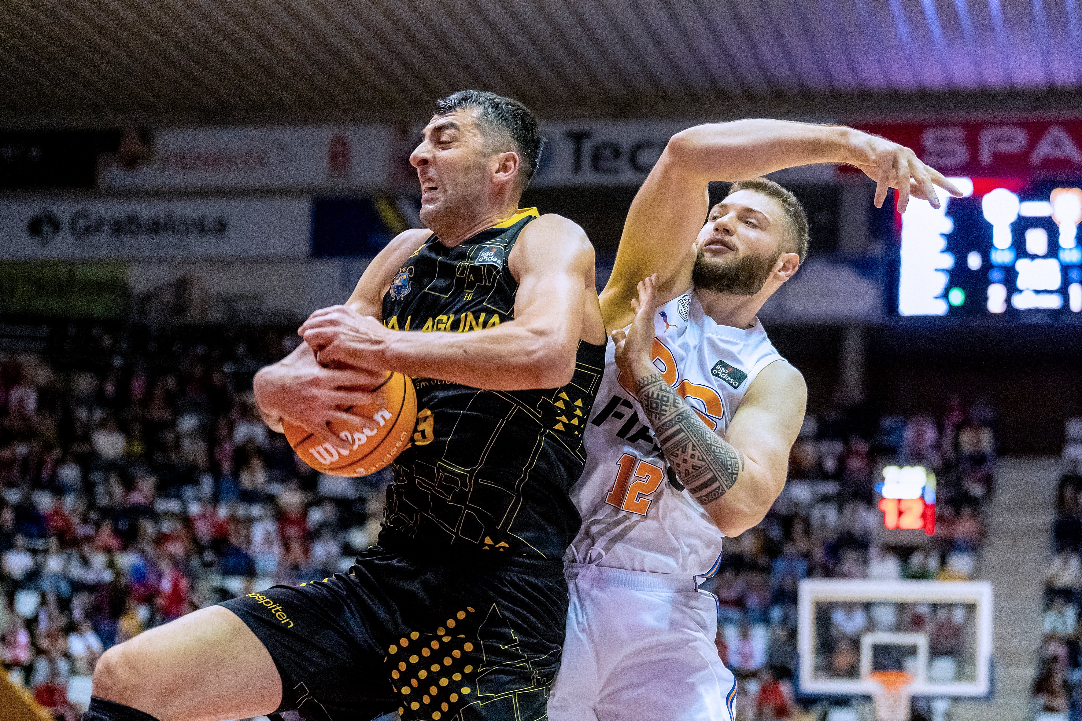 GIRONA, 20/12/2025.- El pívot del Tenerife Giorgi Shermadini (i) entra a canasta ante el pívot del Girona Martinas Geben (d) durante el encuentro de Liga Endesa entre Bàsquet Girona y La Laguna Tenerife celebrado este sábado en el pabellón de Fontajau, en Girona. EFE/ David Borrat