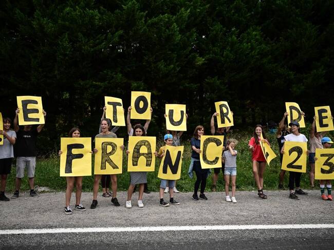 Un grupo de niños saluda al pelotón del Tour de Francia