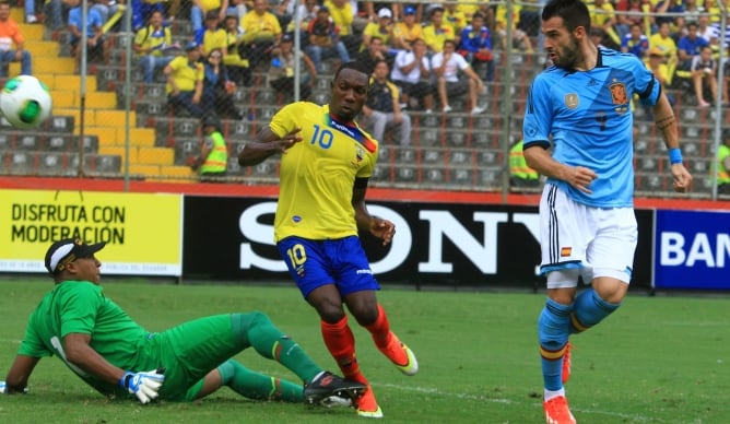 Los jugadores de la selección de Ecuador Walter Ayovi y Maximo Banguera (i) disputan el balón con Álvaro Negredo  de España