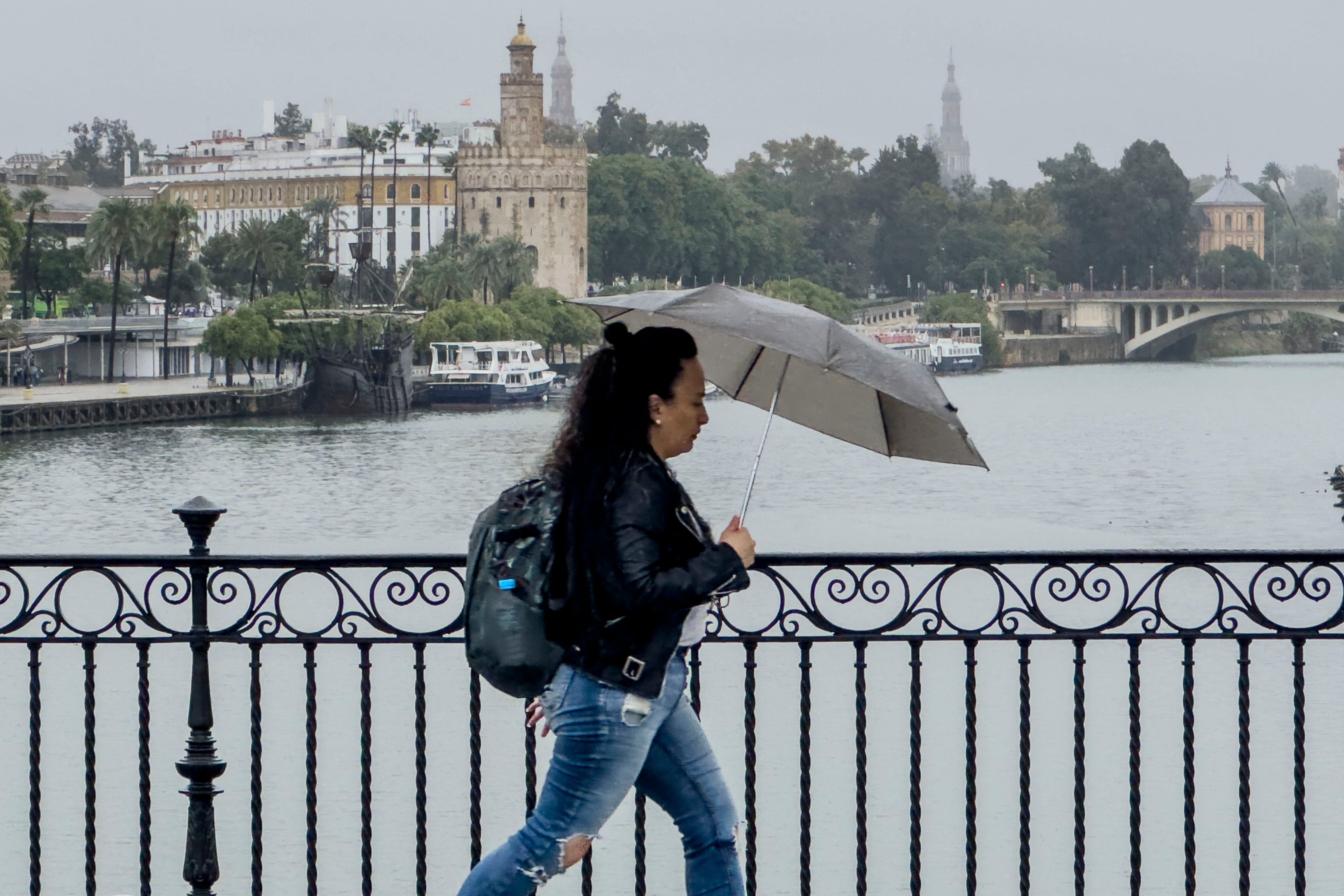 Imagen de archivo de una mujer bajo la lluvia en Sevilla