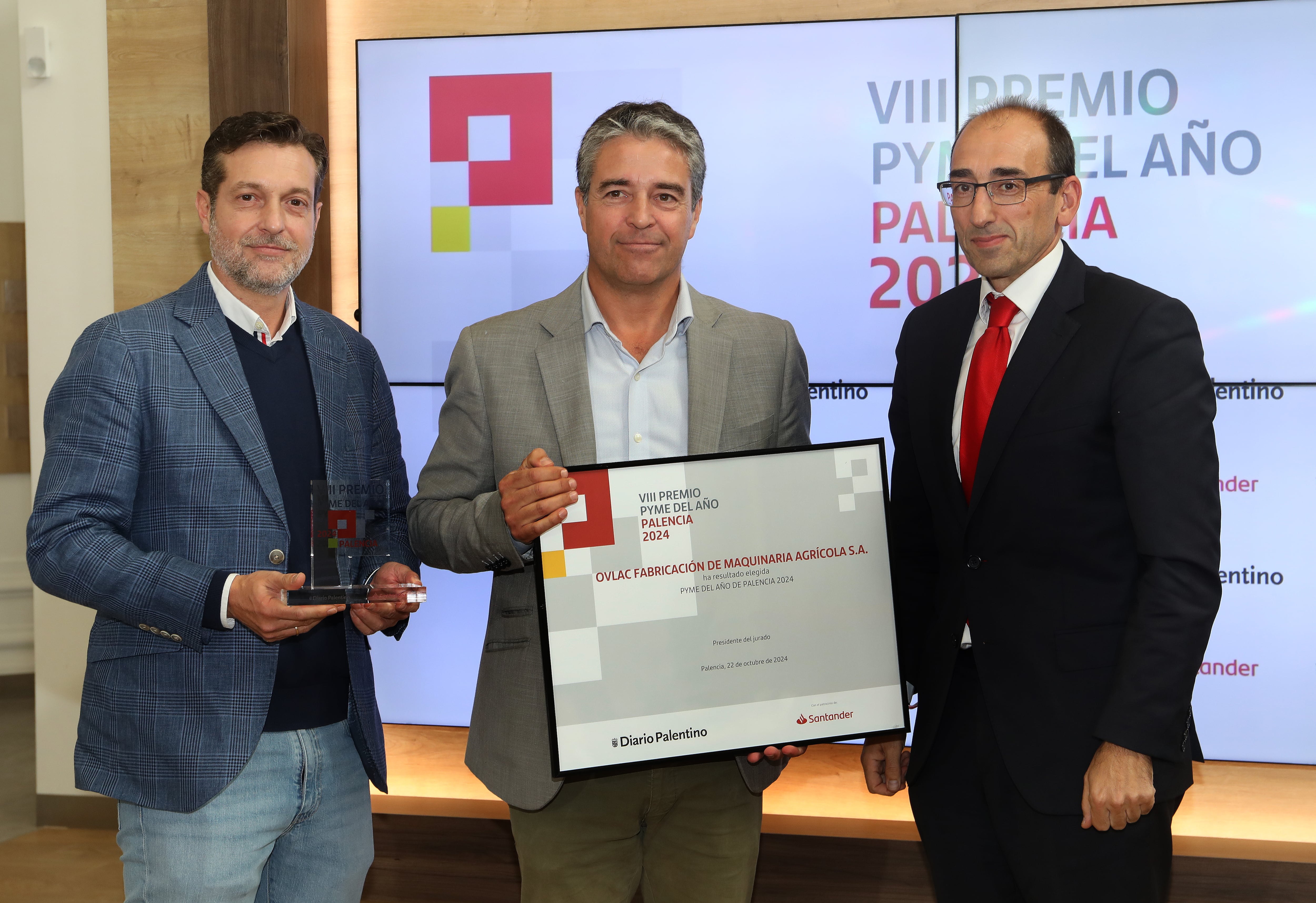 Los empresarios César y Jorge Calvo de la empresa OVLAC de maquinaria agrícola reciben el premio Pyme del año de manos del director territorial en Castilla y León del banco Santander, Javier Martín (D)